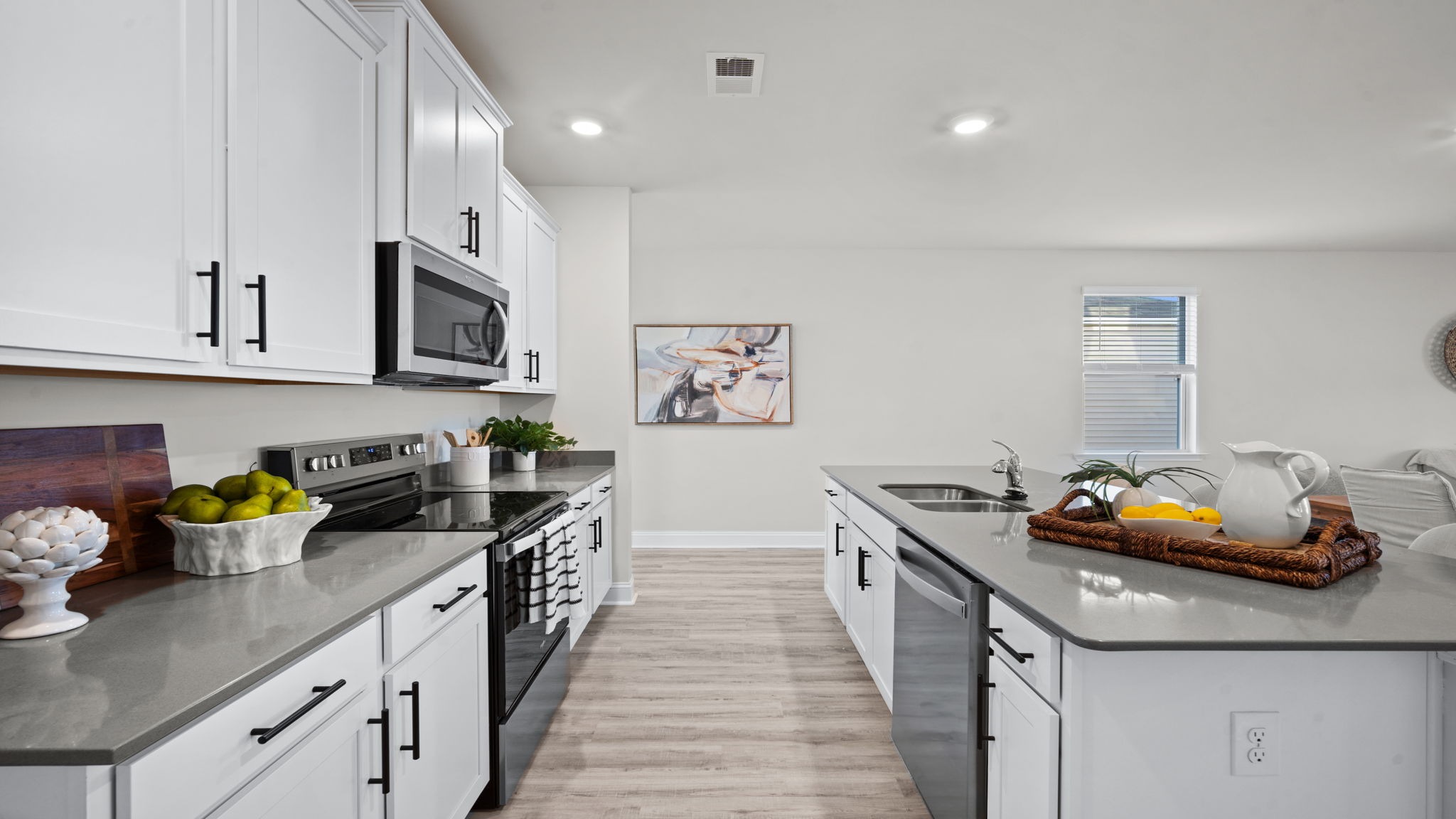 “Modern kitchen in Manning floor plan featuring large center island, natural gas appliances, and open layout for entertaining.”