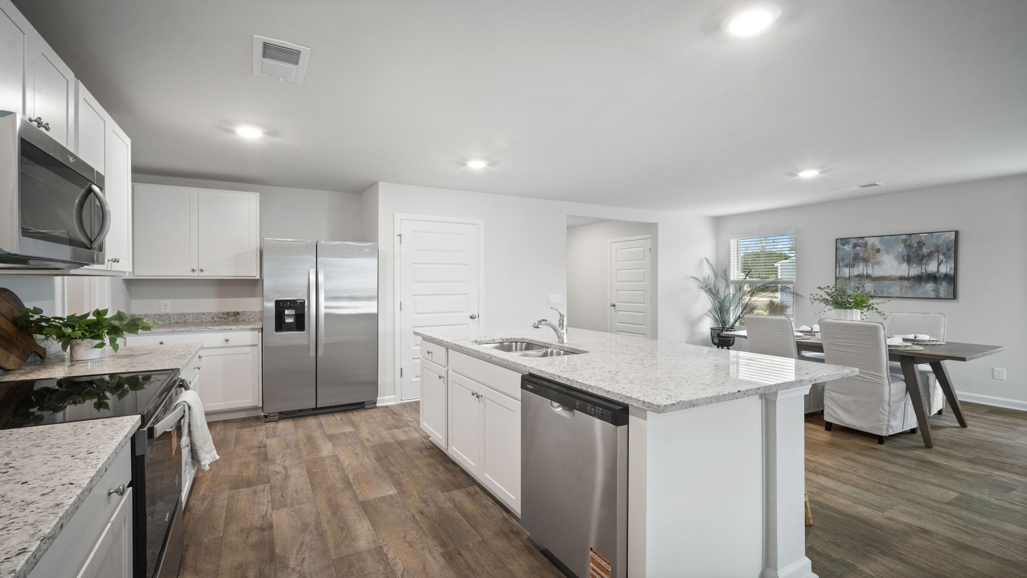 Kitchen with a view of the island with a stainless dishwasher and the dining area