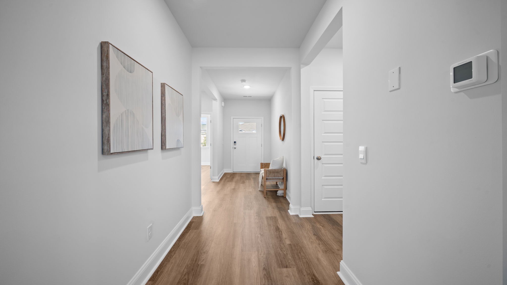 Front entryway and foyer with hardwood floors and dining area next to it.