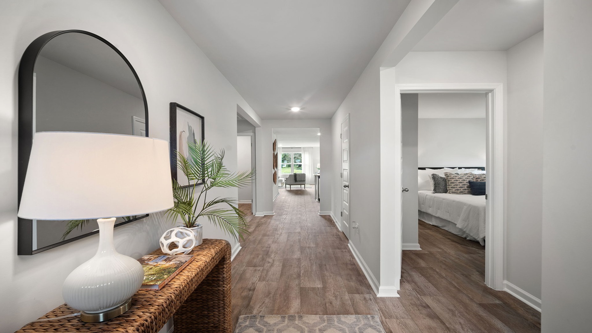 Front entryway and foyer with hardwood floors and  hall leading into the kitchen and living area.
