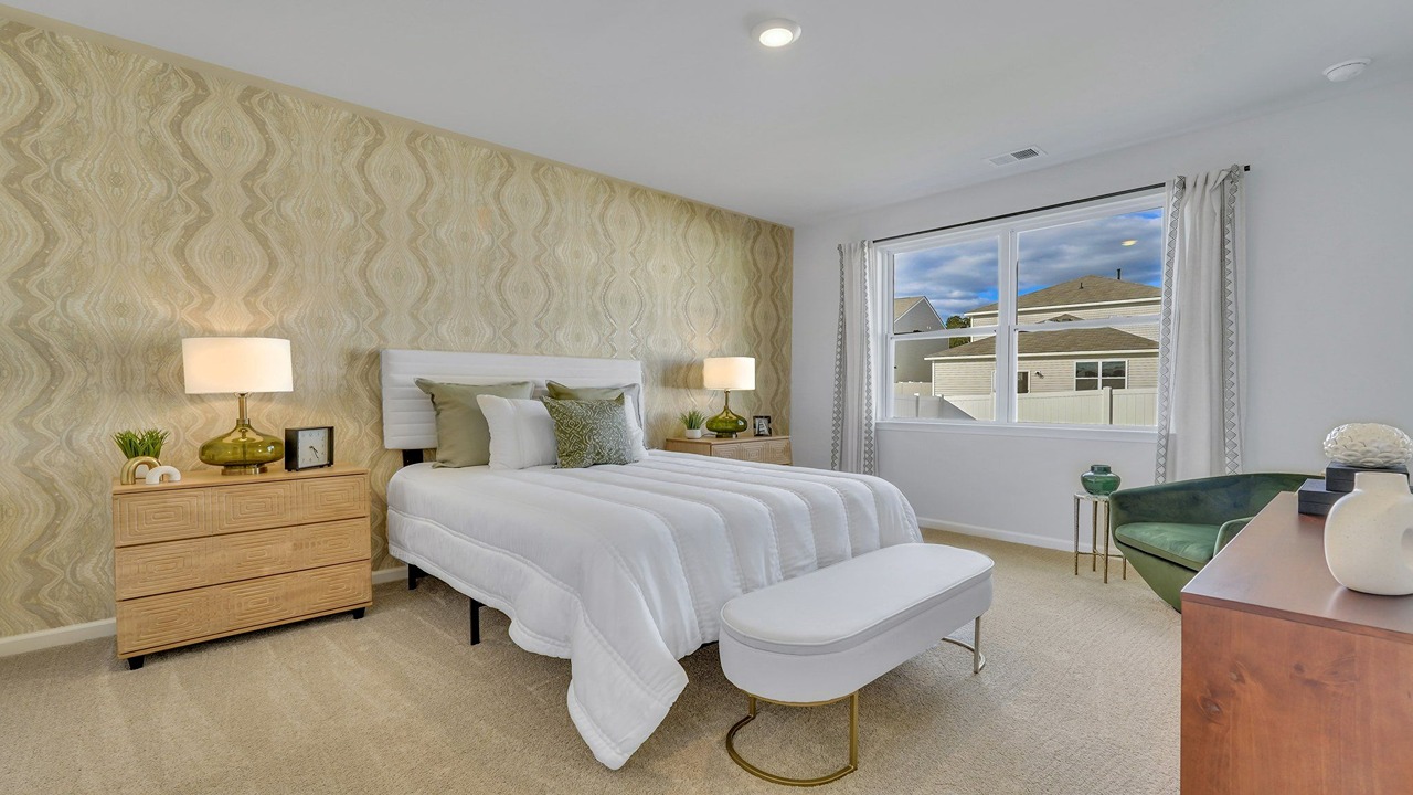 Primary bedroom decorated with a bed and side table