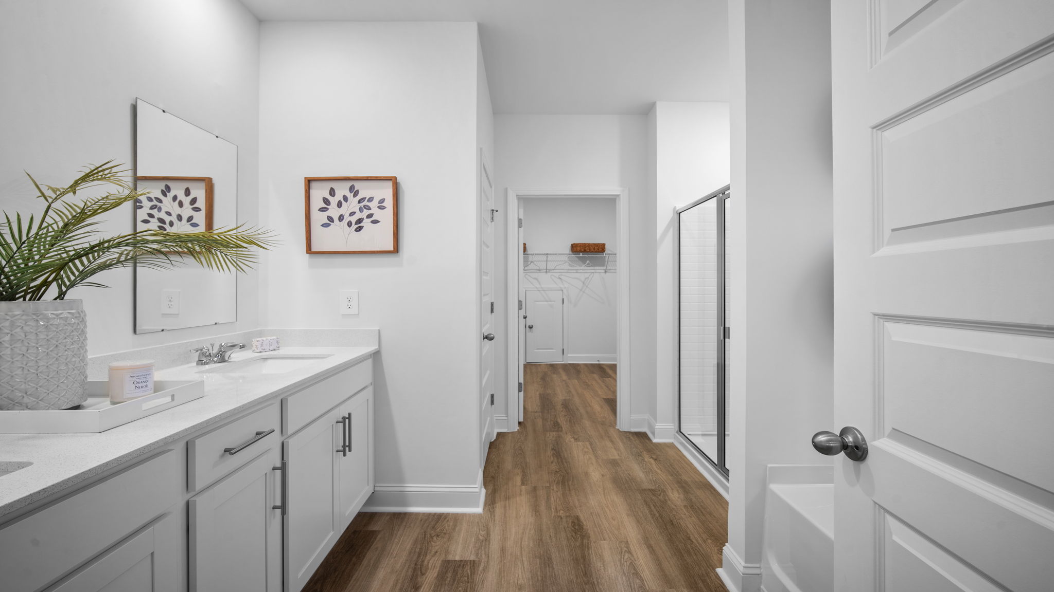 Primary bathroom with double vanities and a stand-up shower
