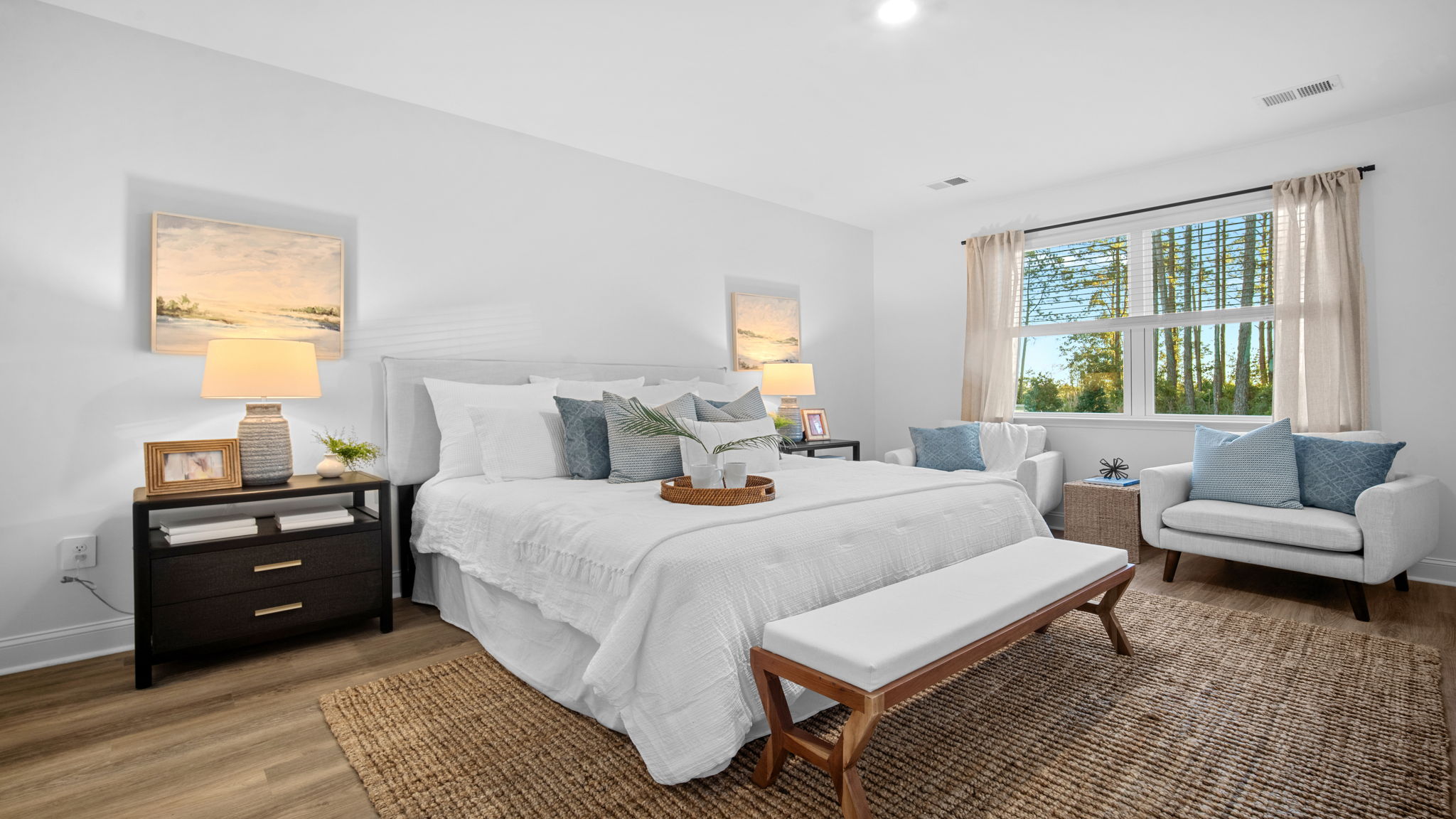 Primary bedroom decorated with a bed, side table and a dresser