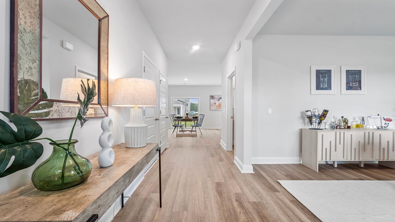 Foyer into home with view of dining table and sliding glass doors