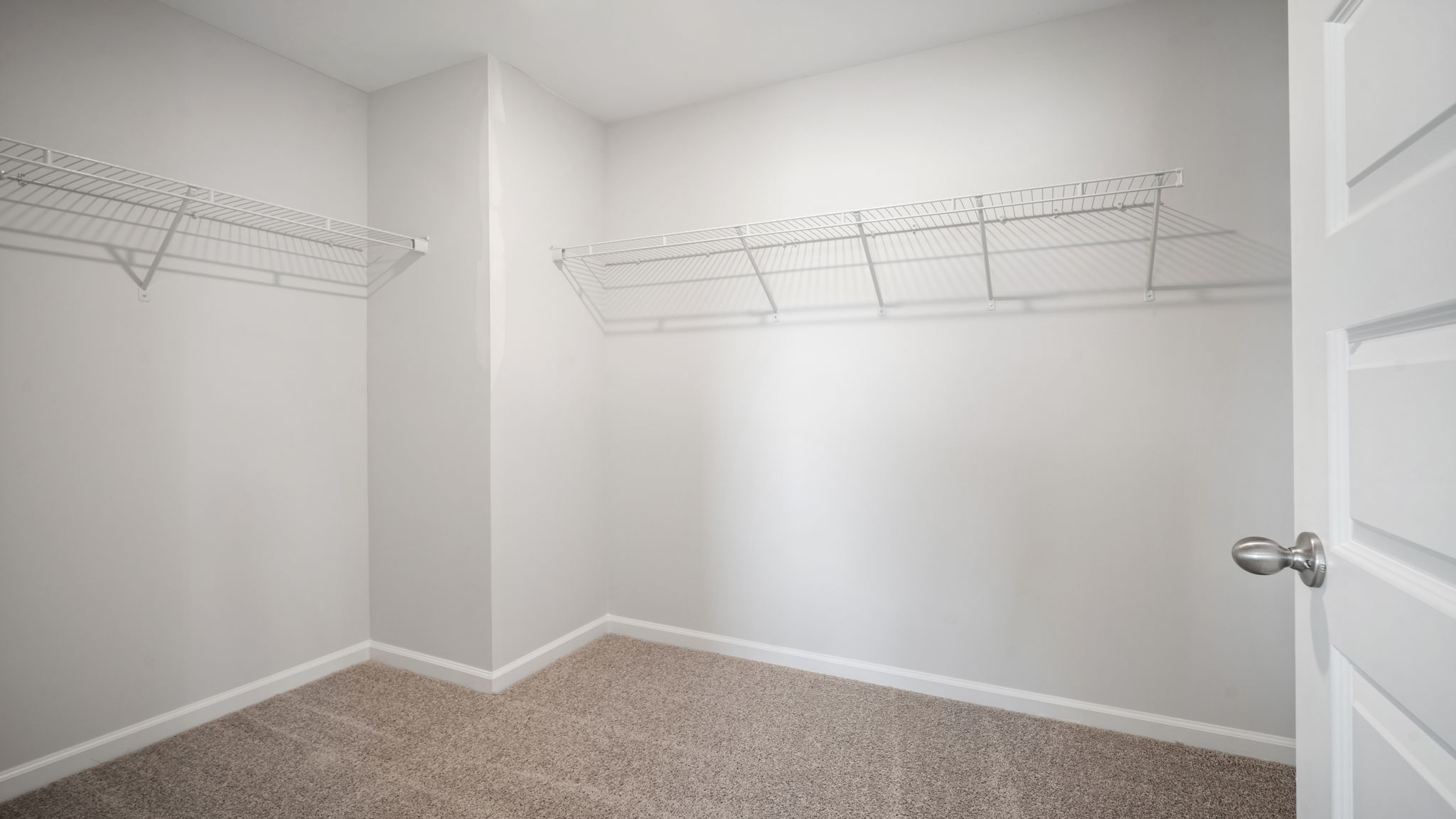 Spacious walk in closet with built in shelving in the primary bathroom.