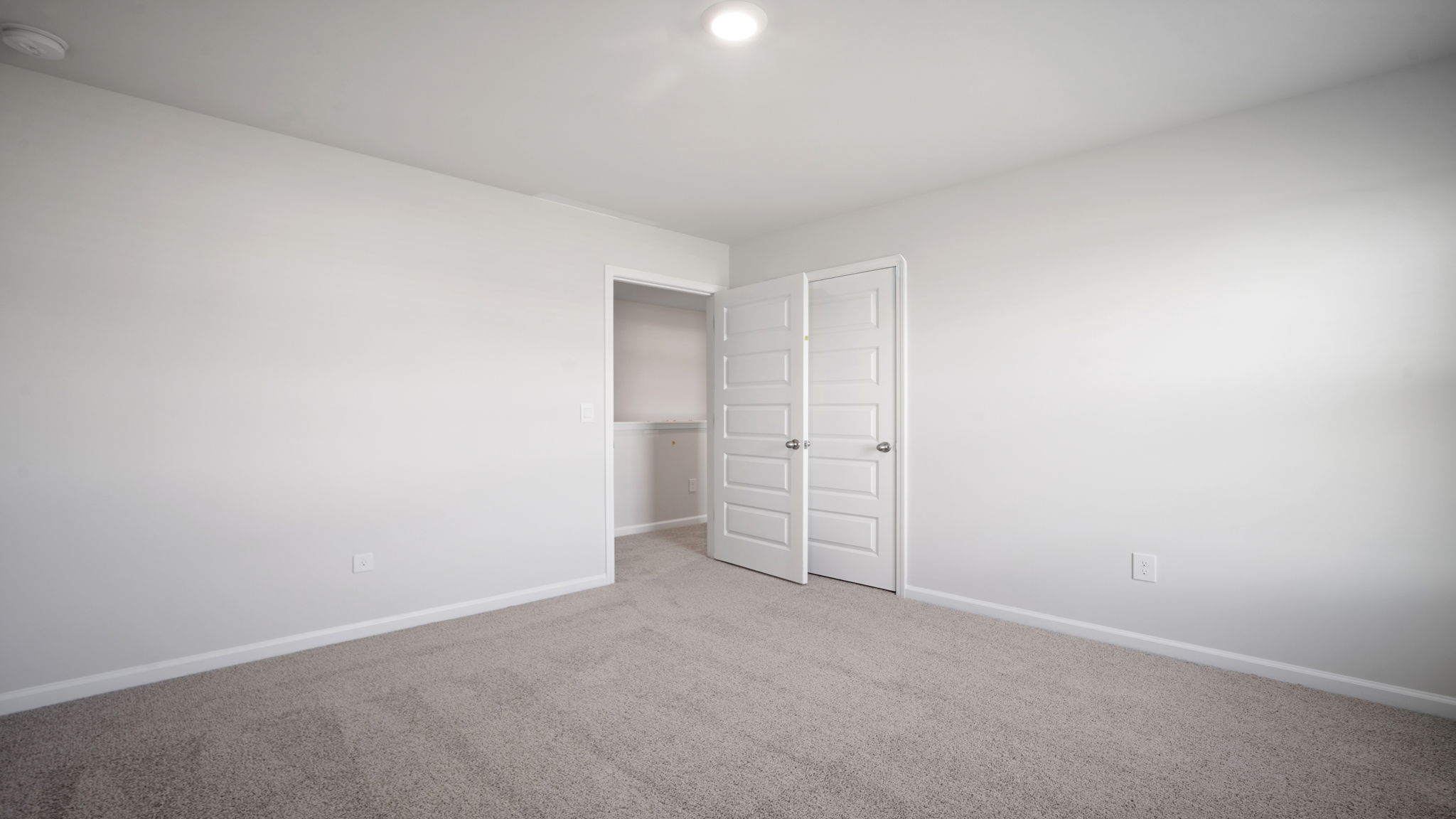 Bedroom with closet door and entry door.