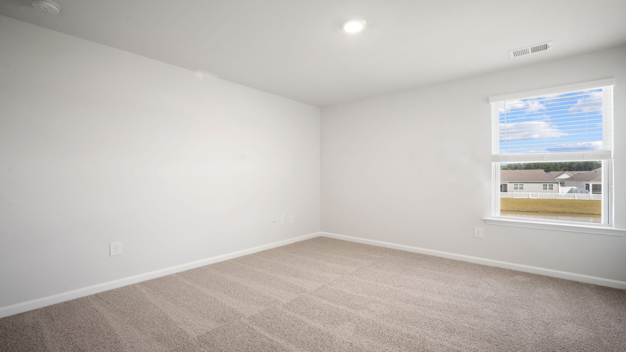Bedroom with carpeted floors and large single window for natural light.