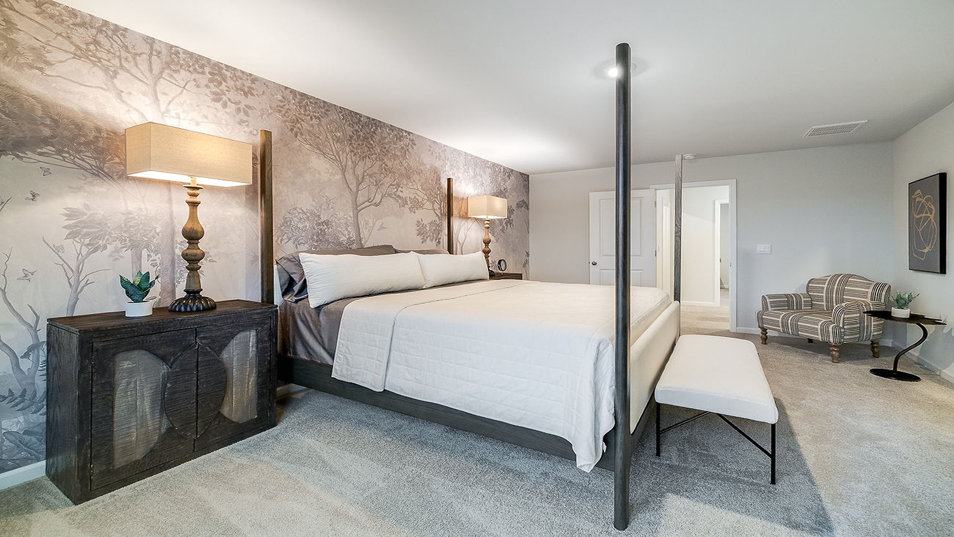 Primary bedroom decorated with a bed, side table and a bench