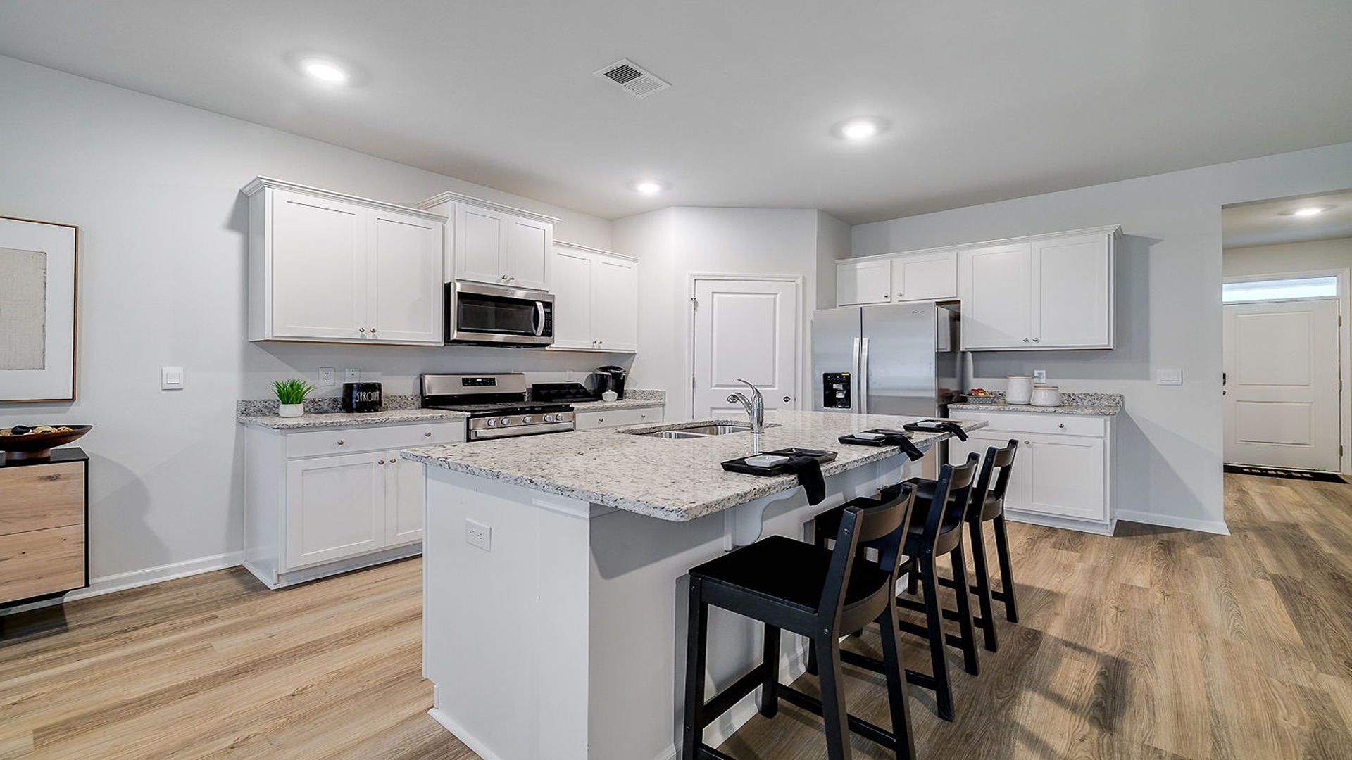 Kitchen island with bar seating and view of the oven range in the background