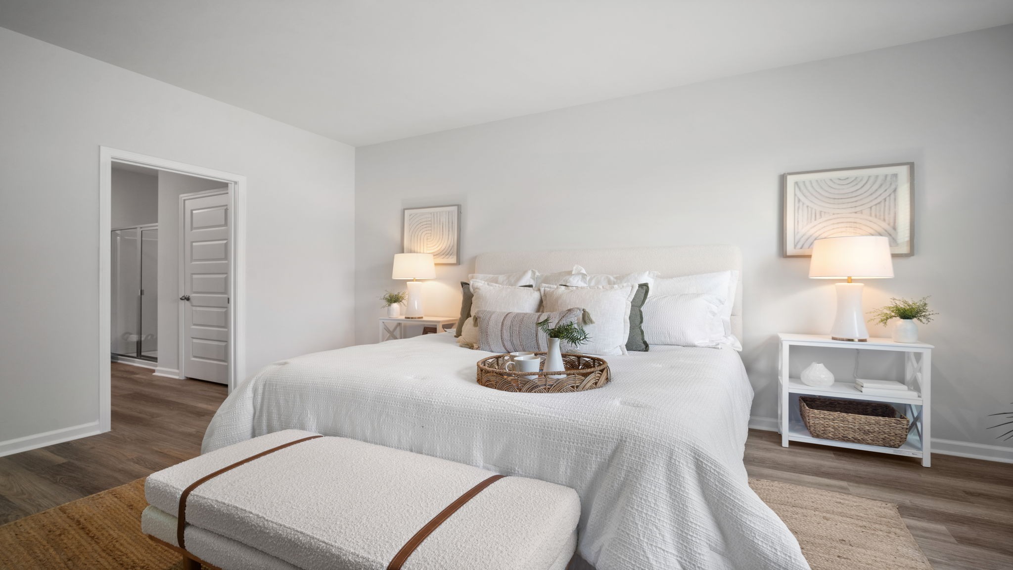 Primary bedroom decorated with a bed , bench, side table and a chair