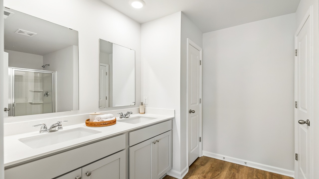 Luxury primary bathroom in the Denmark floor plan at Old Bailey featuring dual vanities, a walk-in shower, and elegant finishes.