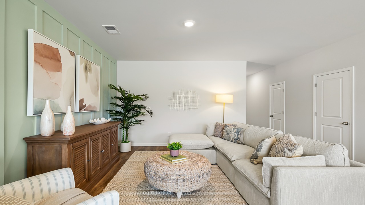 Spacious family room in the Denmark floor plan showcasing open sightlines and seamless flow to the kitchen and dining area.