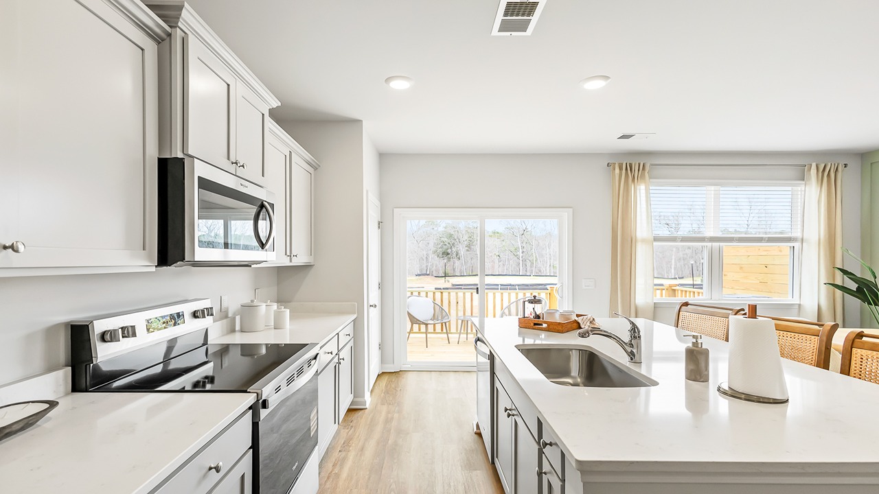 Chef-inspired kitchen in the Denmark floor plan featuring granite countertops, stainless steel appliances, a large center island, and abundant cabinet space.