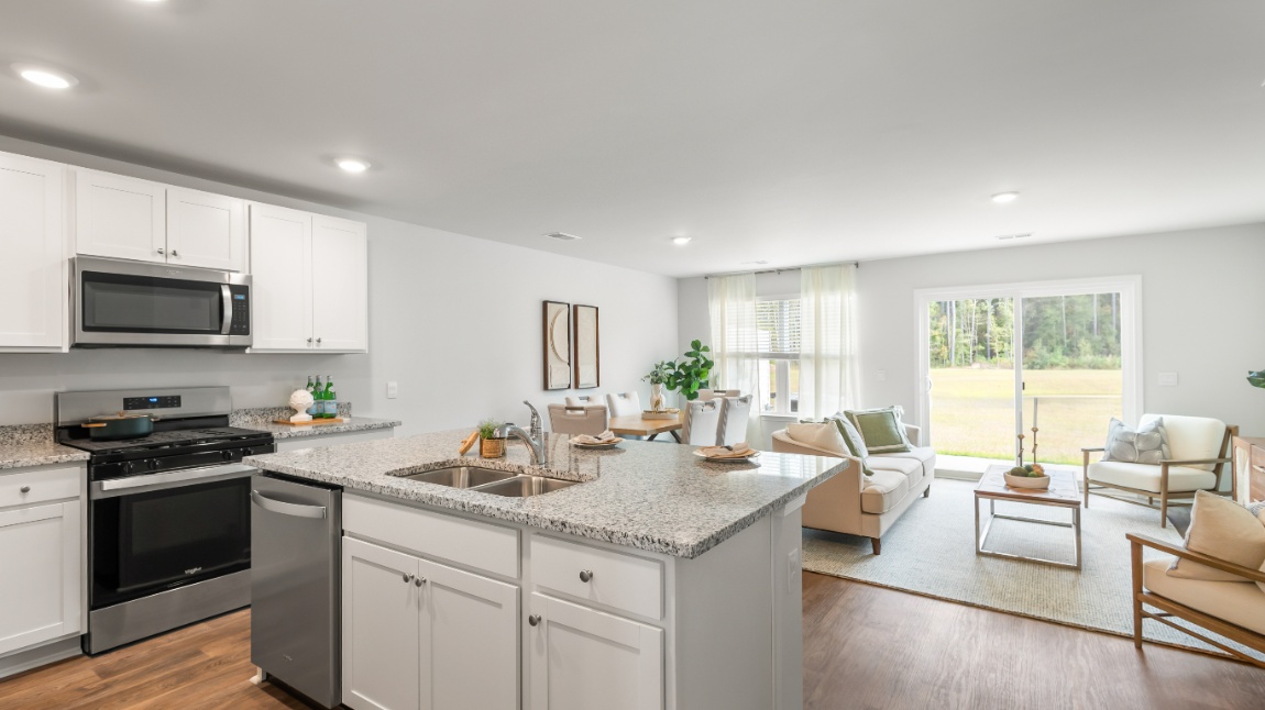 Chef-inspired kitchen in the Davis floor plan featuring granite countertops, stainless steel appliances, a large center island, and ample cabinet storage.