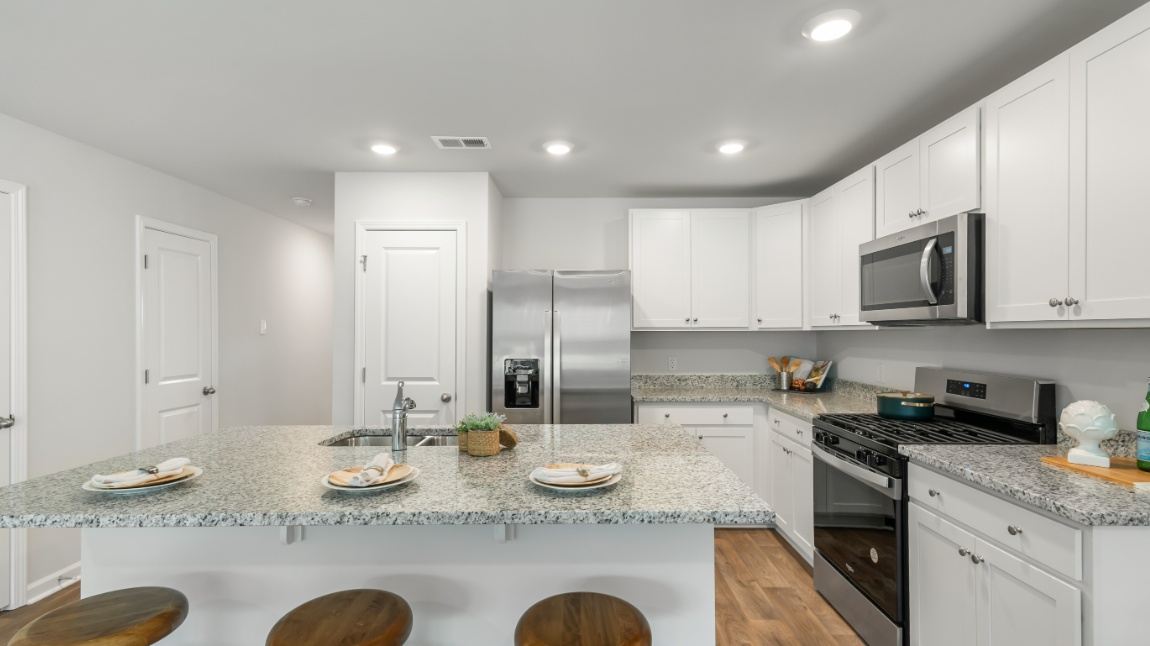Open kitchen in the Davis home at Old Bailey designed for everyday living with generous counter space, modern appliances, and elegant finishes.