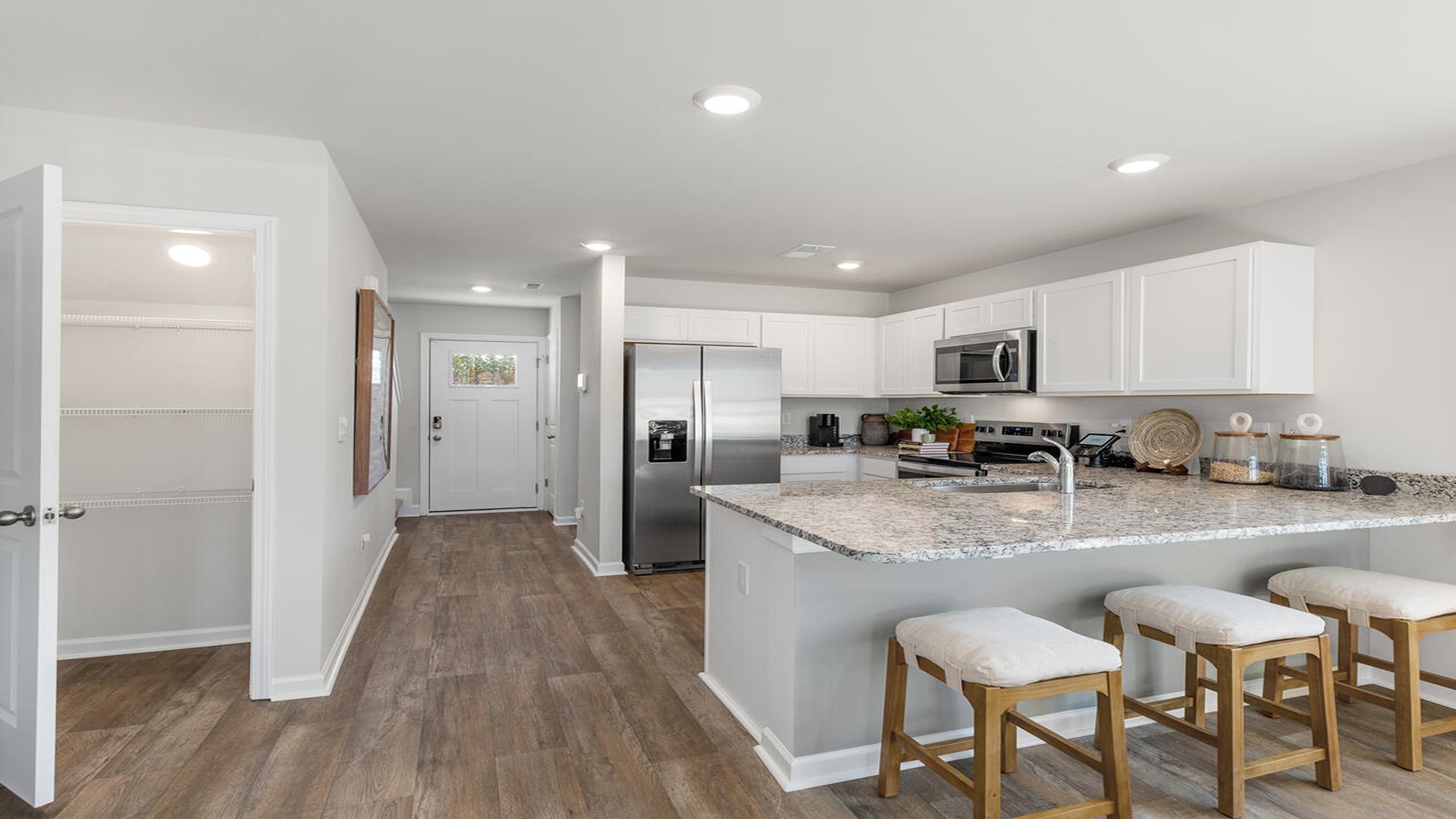 Chef-inspired kitchen in the Norman floor plan featuring granite countertops, large center island, stainless steel appliances, and ample cabinet storage.