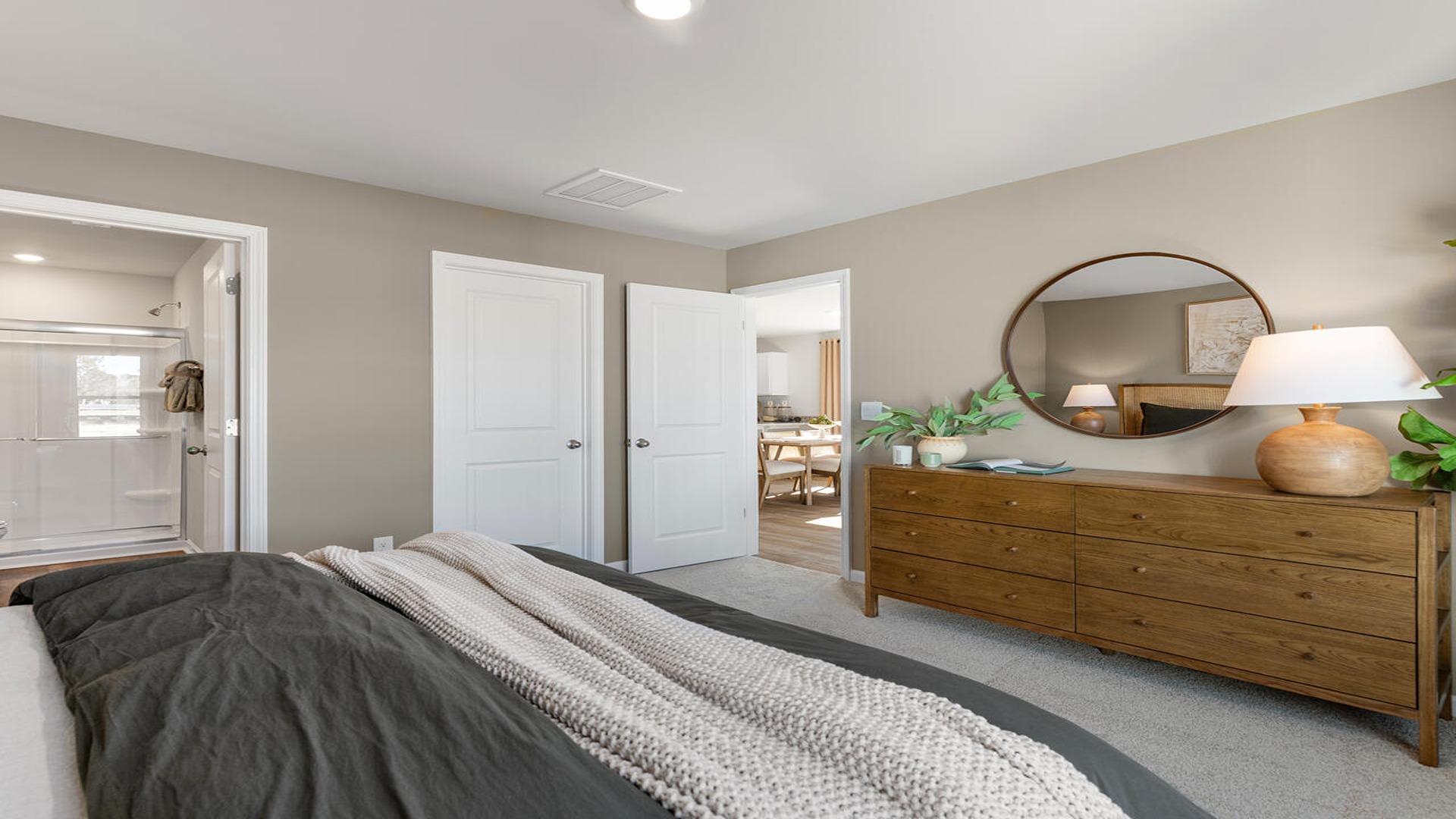 Owner's suite in the Norman home showcasing modern finishes, generous square footage, and abundant natural light.