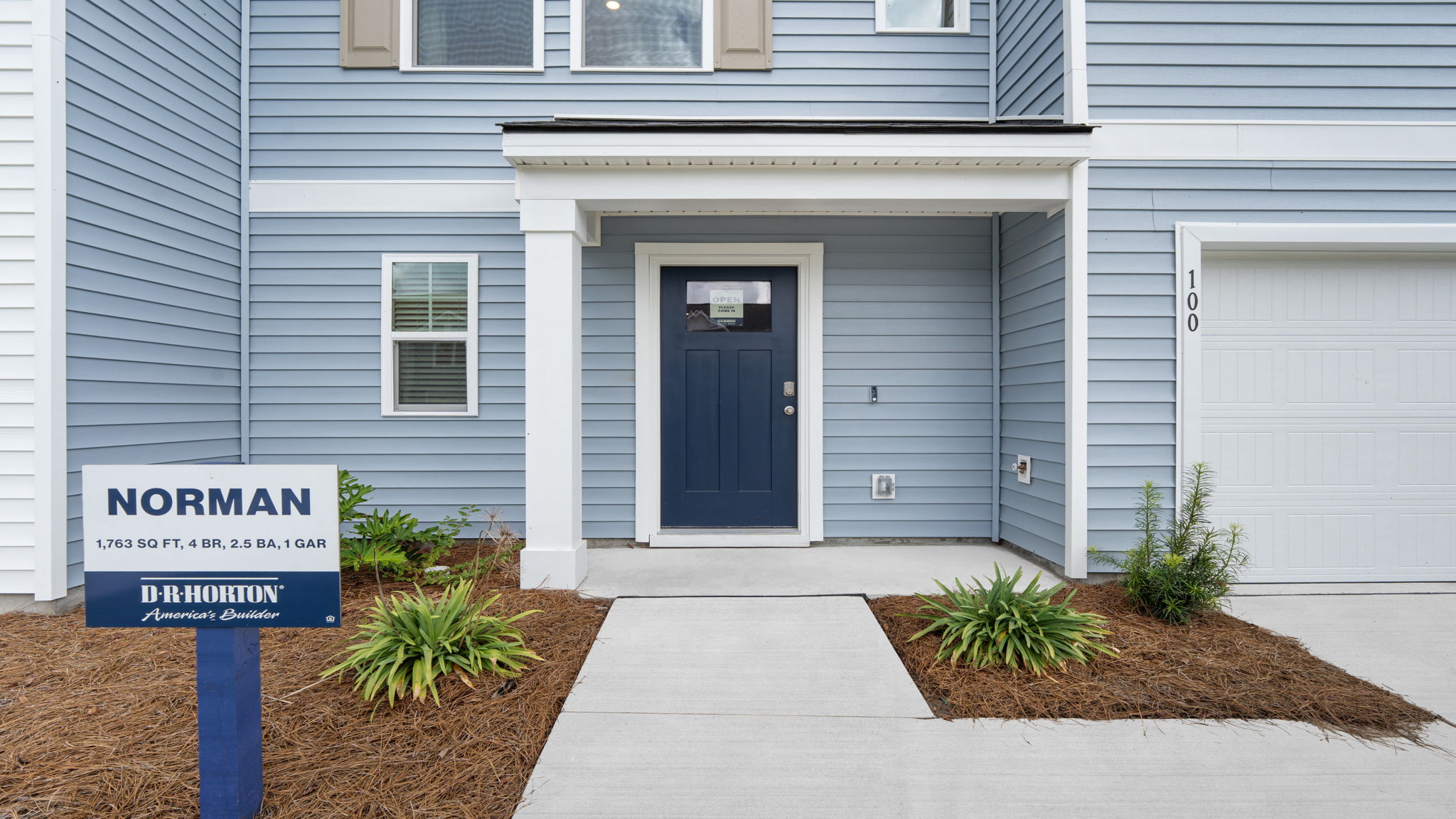 Covered front porch entry of the Norman townhome with welcoming curb appeal and exterior detail