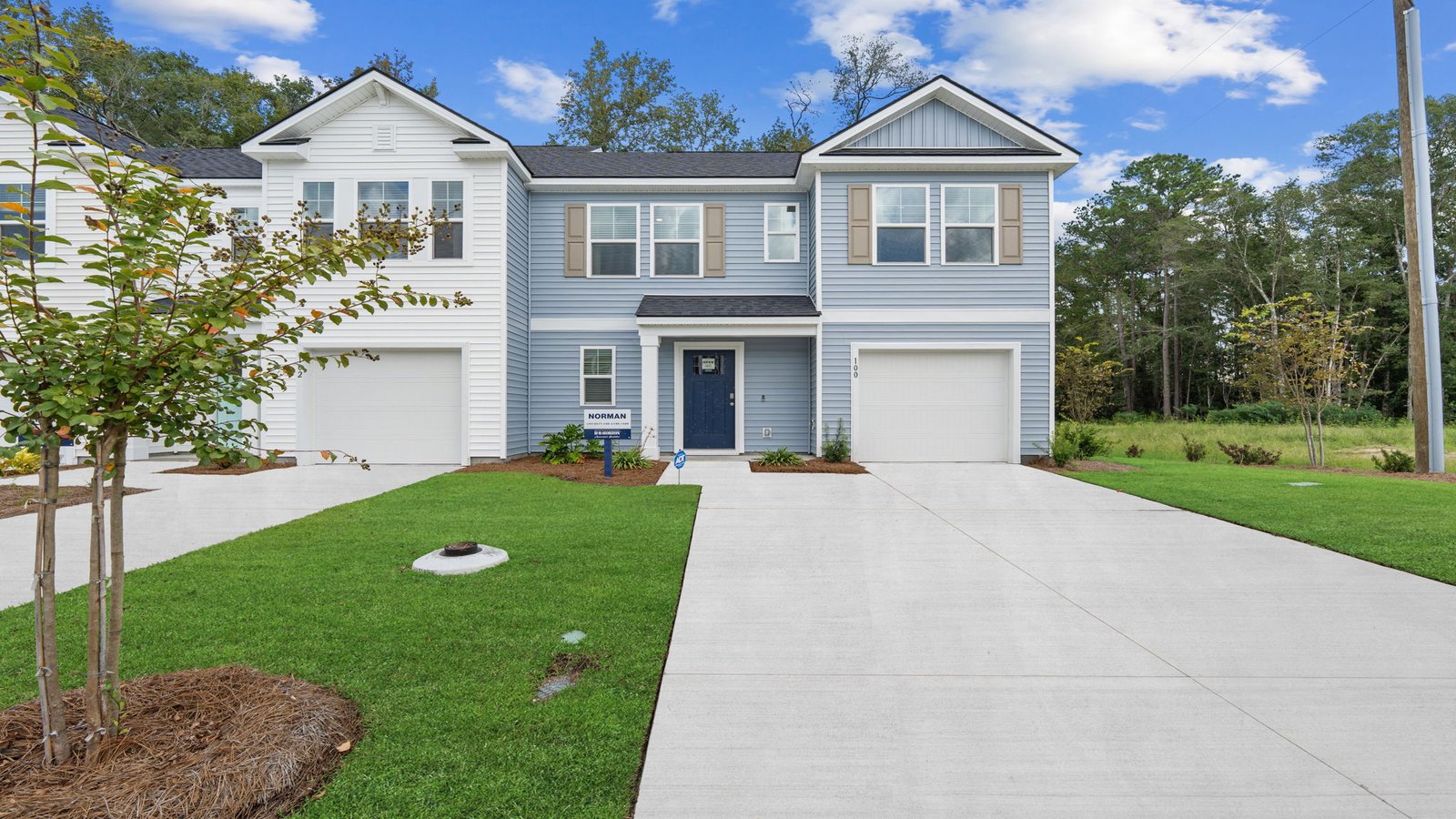 Front exterior view of the Norman townhome showcasing garage, entryway, and attractive architectural design