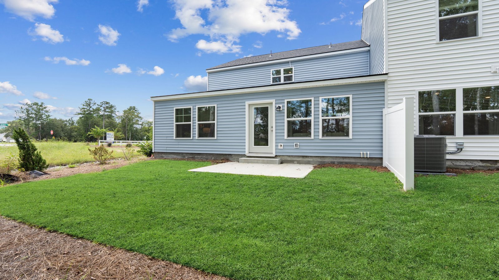 Rear exterior of the Norman townhome featuring backyard space and exterior entertaining area