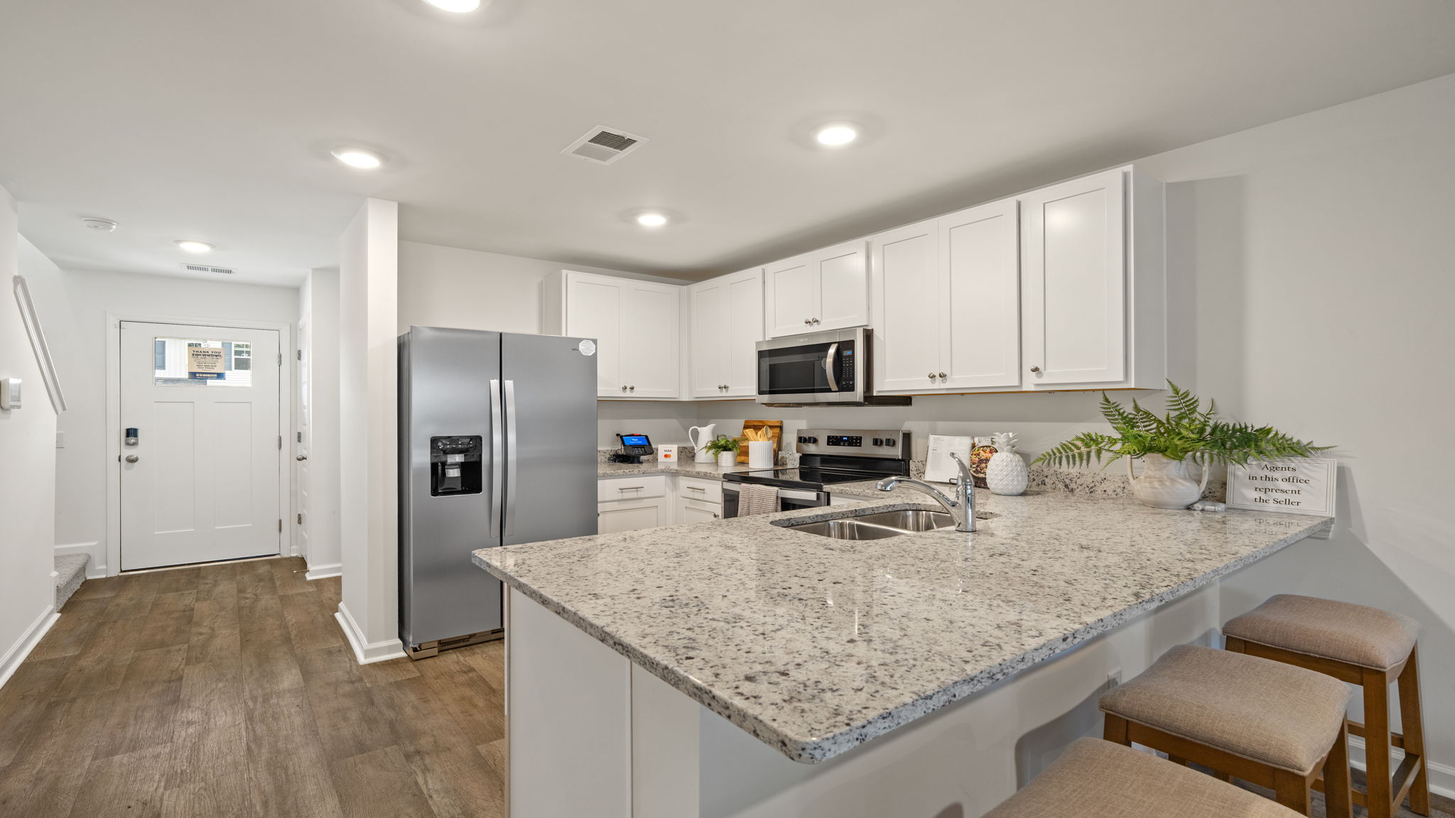 Modern kitchen in the Norman townhome with granite countertops, center island, stainless steel appliances, and open-concept layout