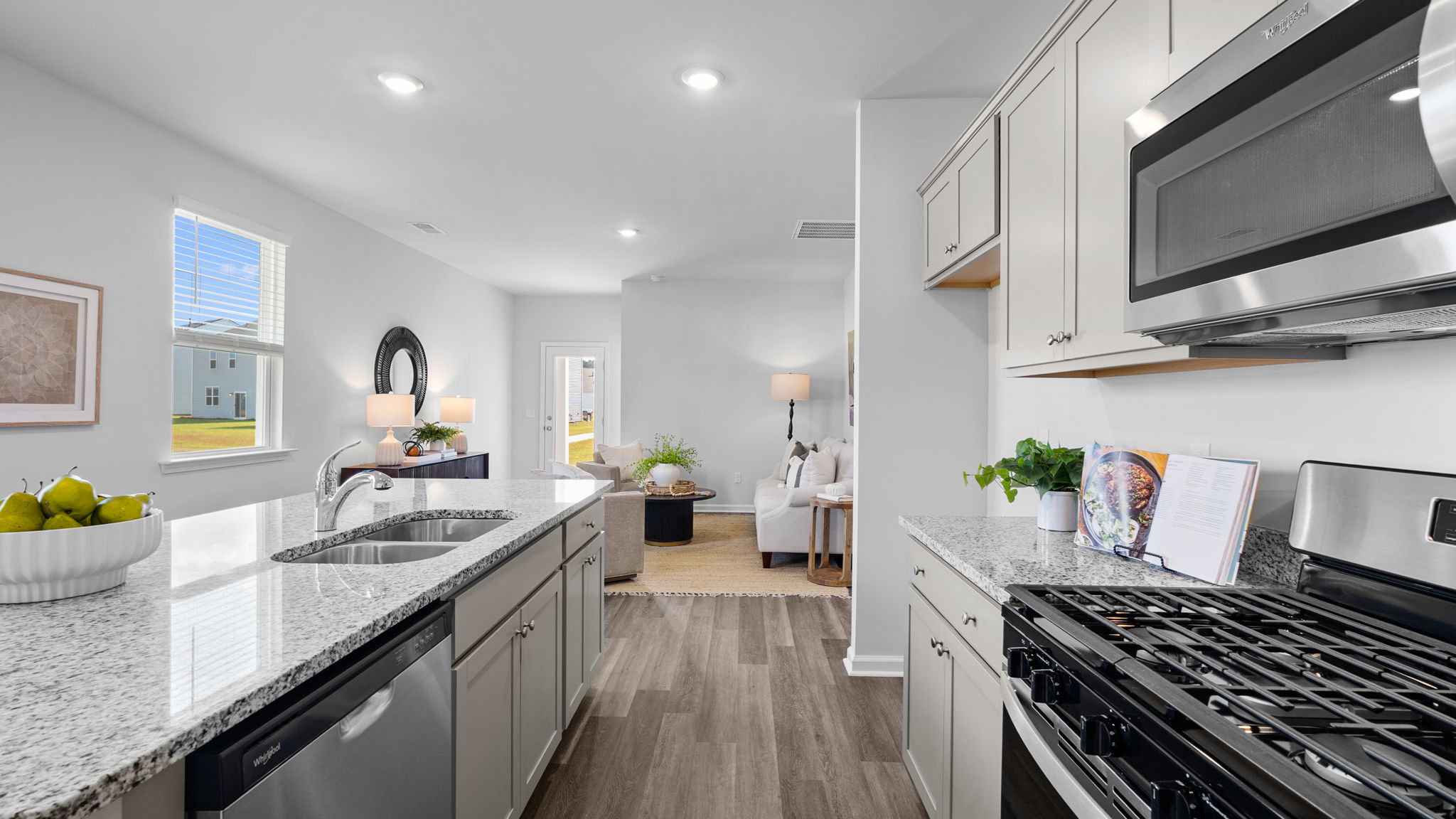 Downing kitchen with granite countertops and stainless steel appliances at The Groves at Bees Creek