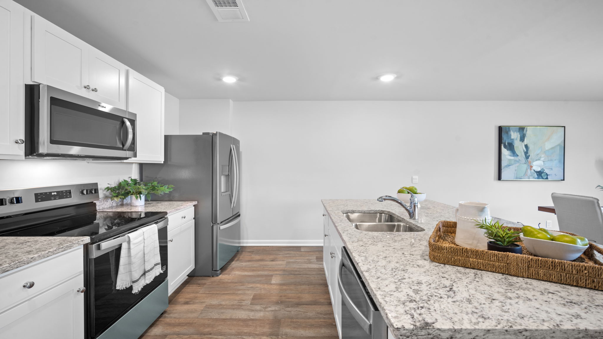 Gourmet kitchen in the D.R. Horton Freeport featuring granite countertops, center island, and stainless-steel appliances