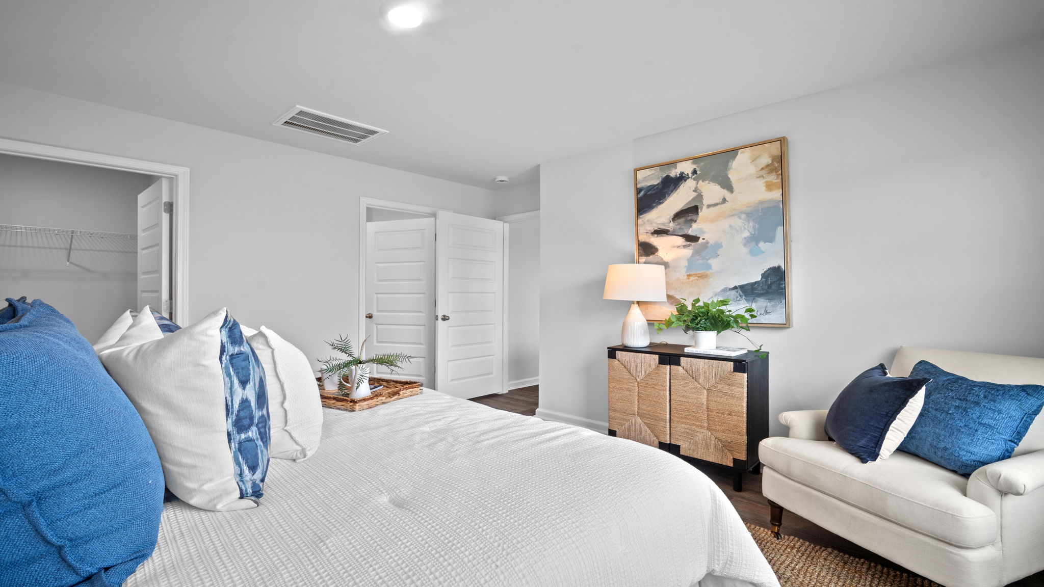 Primary bedroom with carpeted floors, large windows, and trey ceilings.