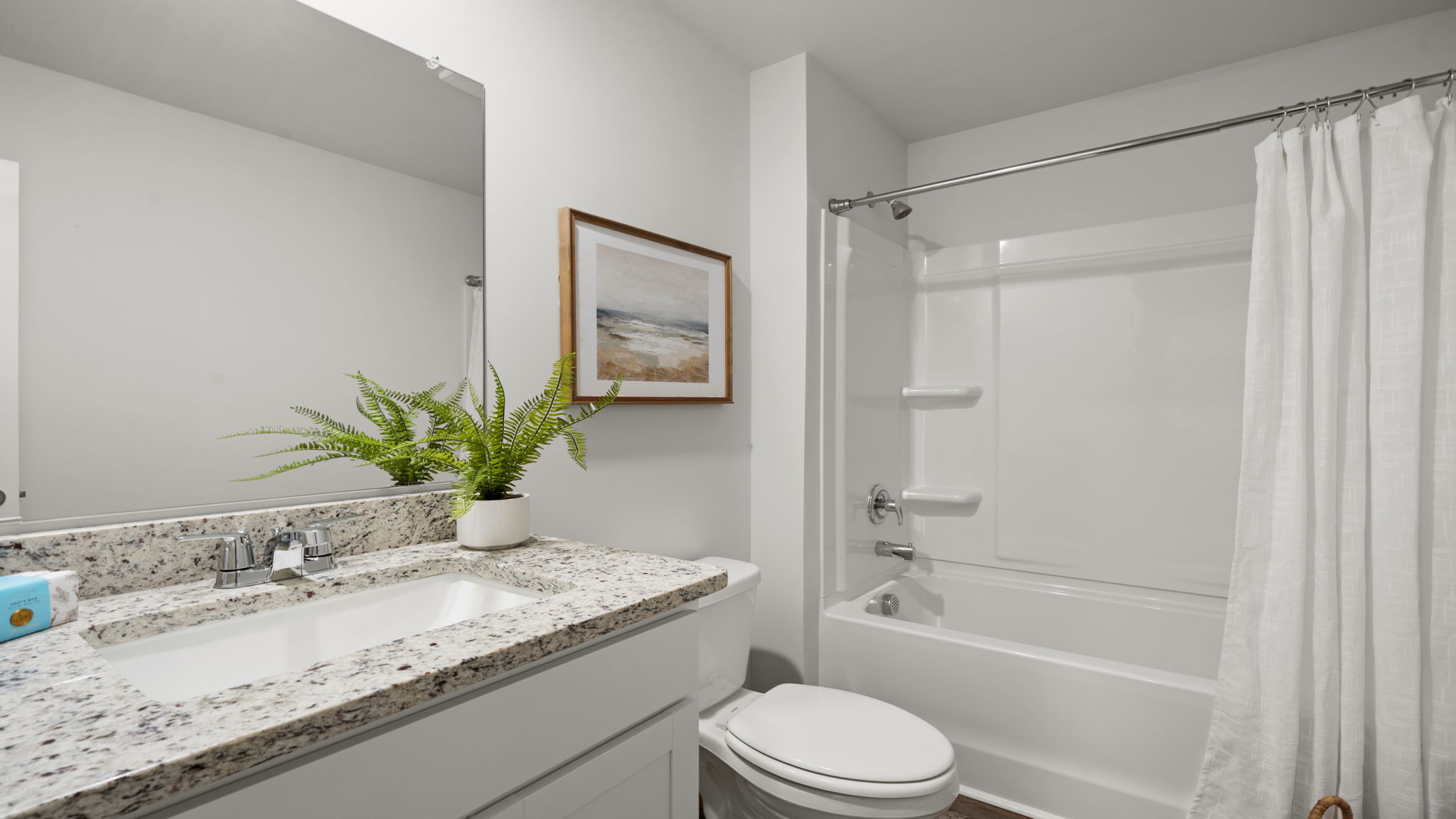 Full secondary bathroom with granite vanity, shower-tub combination, and modern finishes.