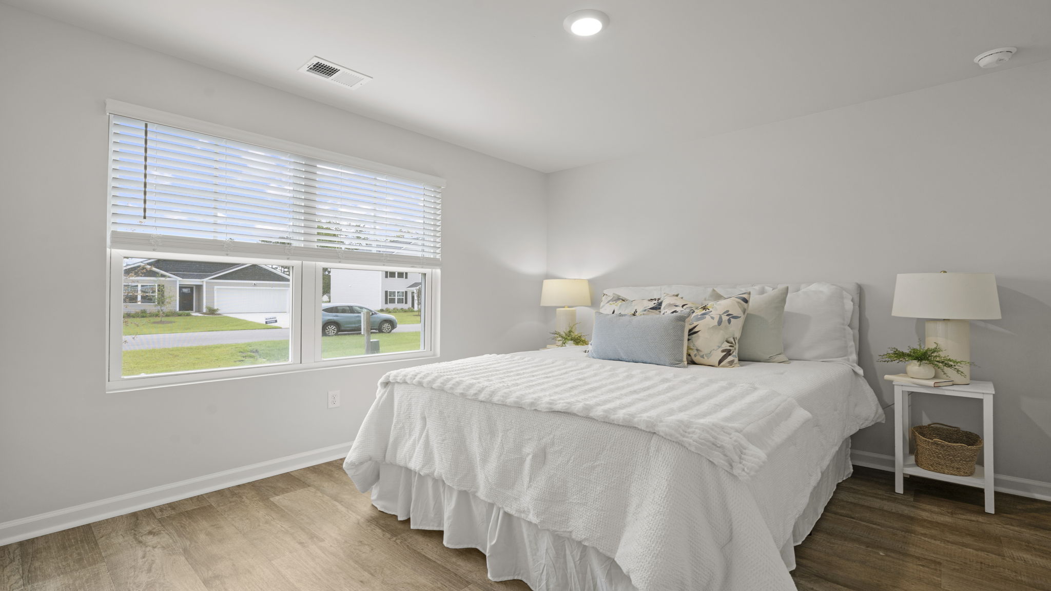 Secondary bedroom with large window, spacious layout, and neutral interior finishes.
