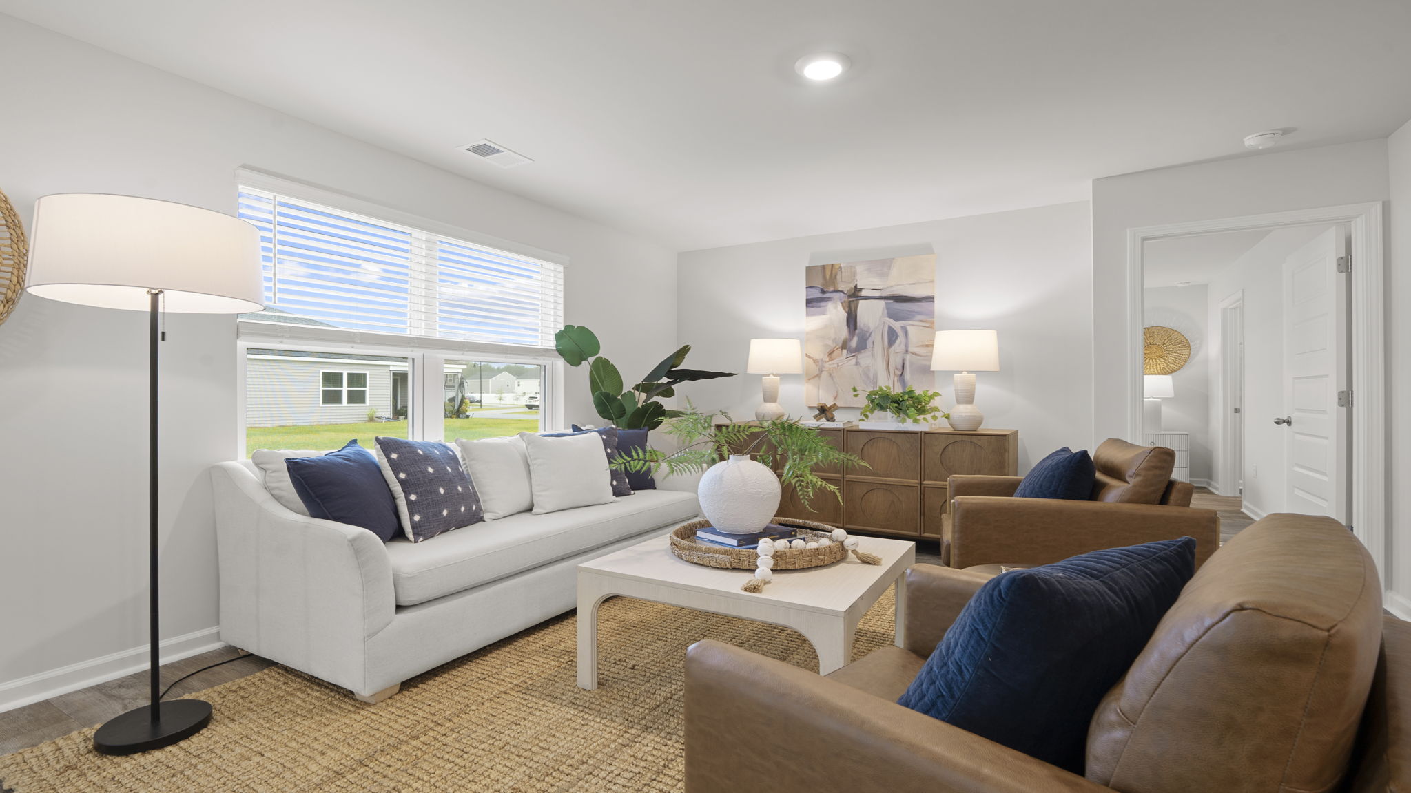Spacious family room with large picture window, open layout, luxury vinyl plank flooring, and contemporary finishes.