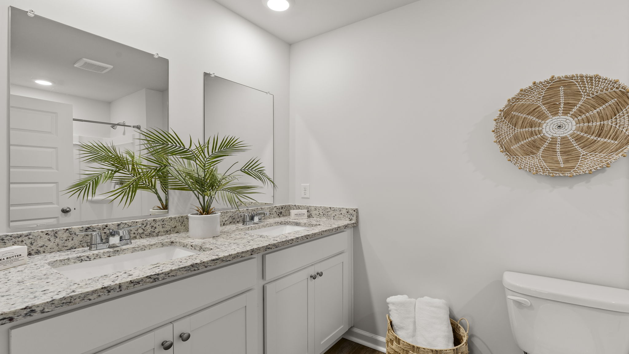 Primary bathroom featuring dual-sink vanity, granite countertops, and modern fixtures.
