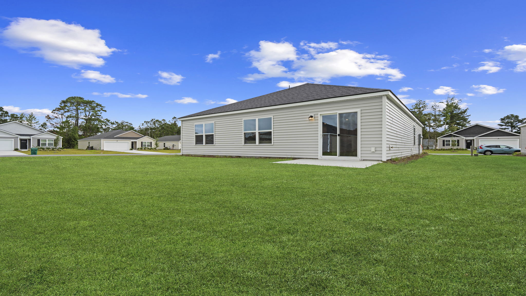 Side and rear exterior view highlighting yard space and single-story home design.