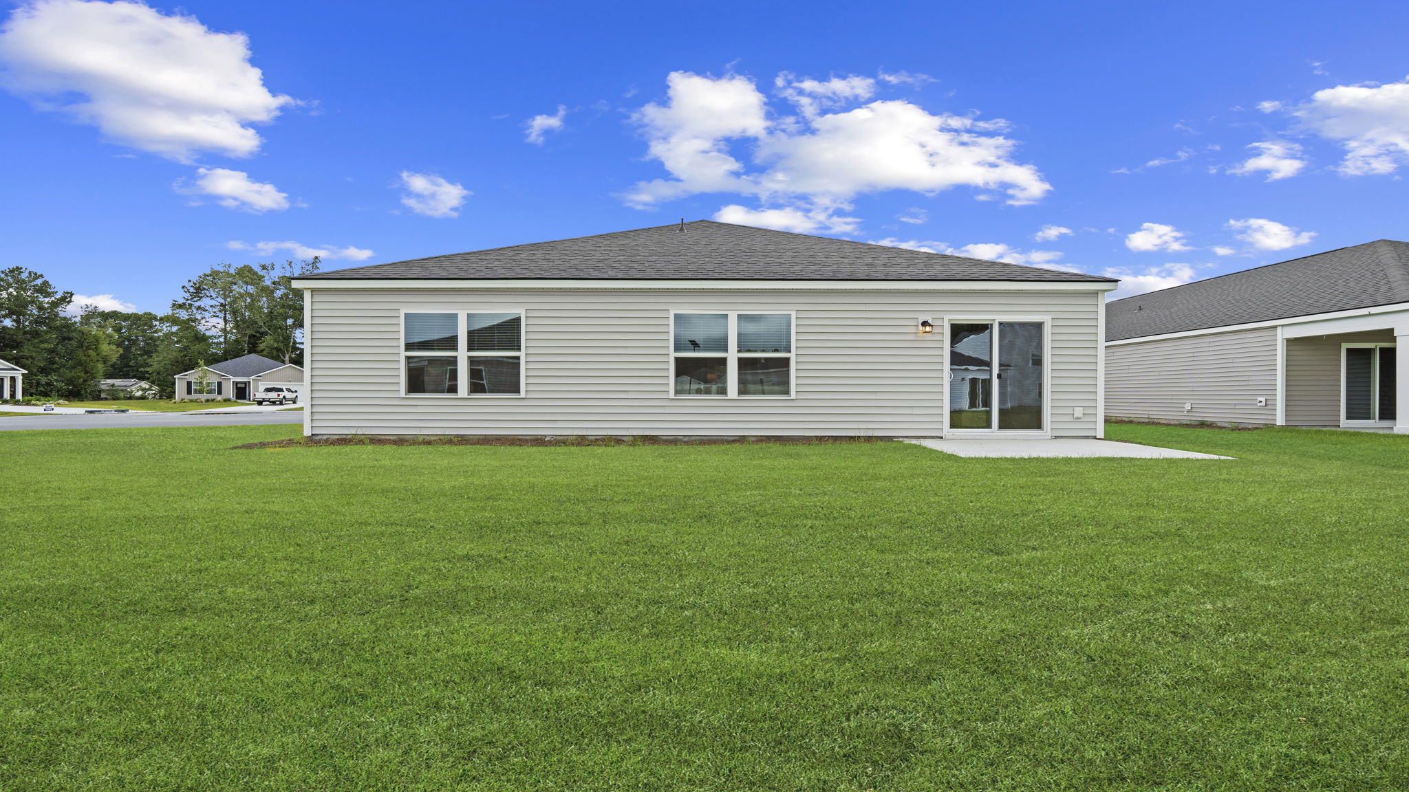 Backyard view showcasing spacious outdoor area and rear elevation of the home.