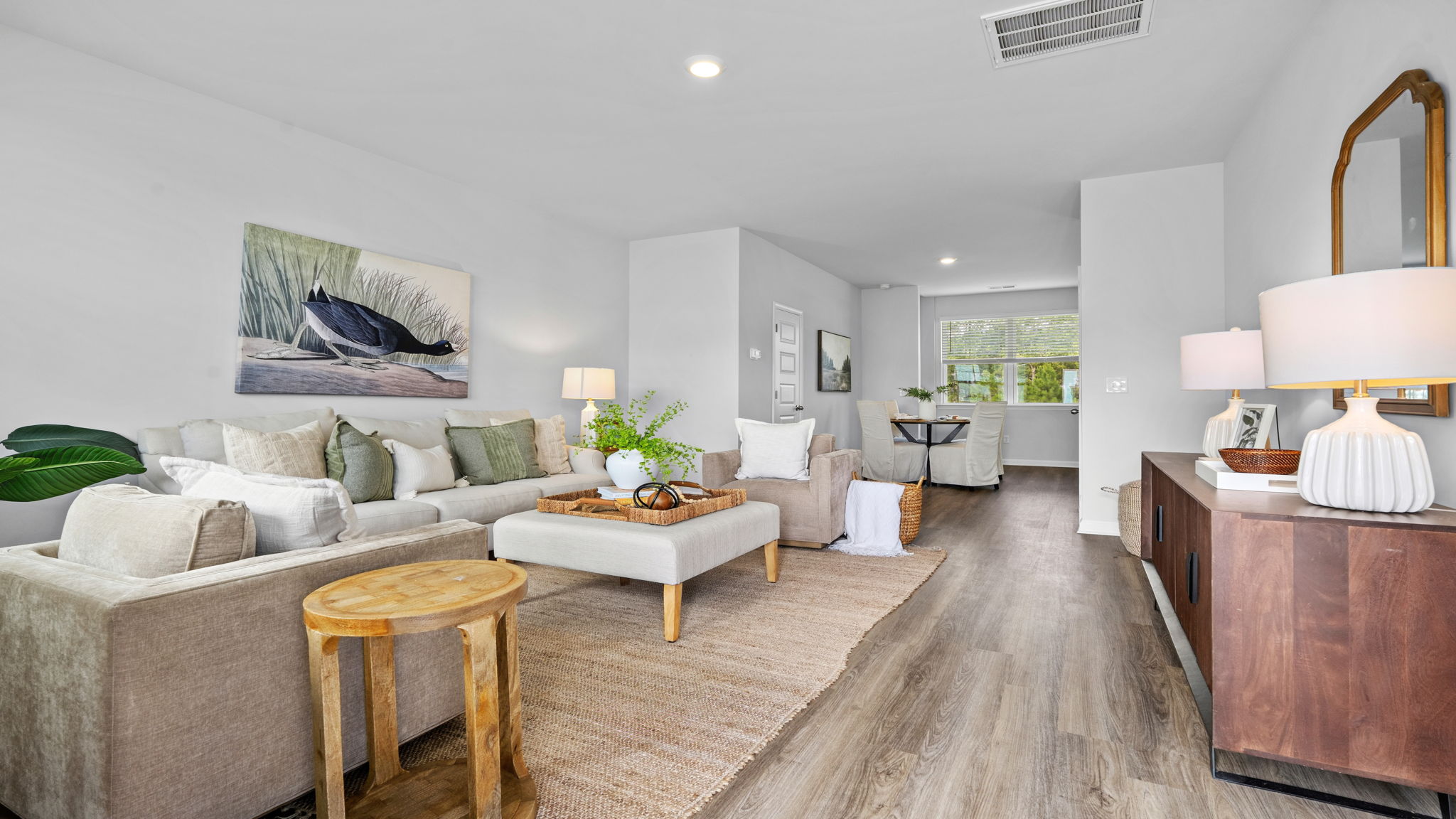 Open-concept dining and living area in a home at The Groves at Bees Creek
