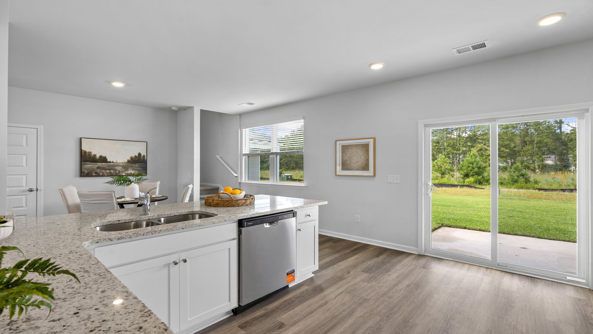 Kitchen with white cabinetry, center island, and backyard views