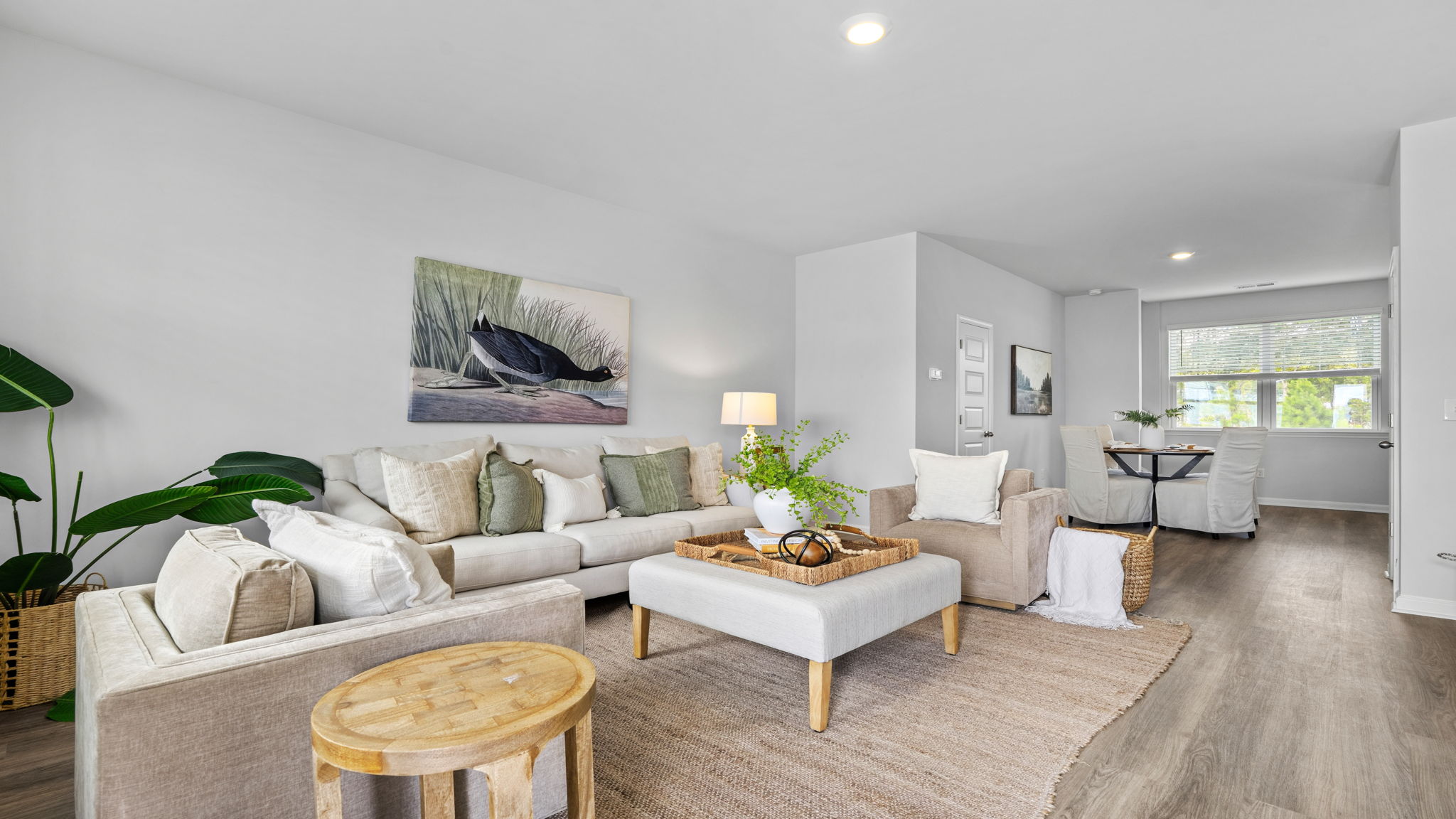 Bright open-concept living room with large windows at The Groves at Bees Creek