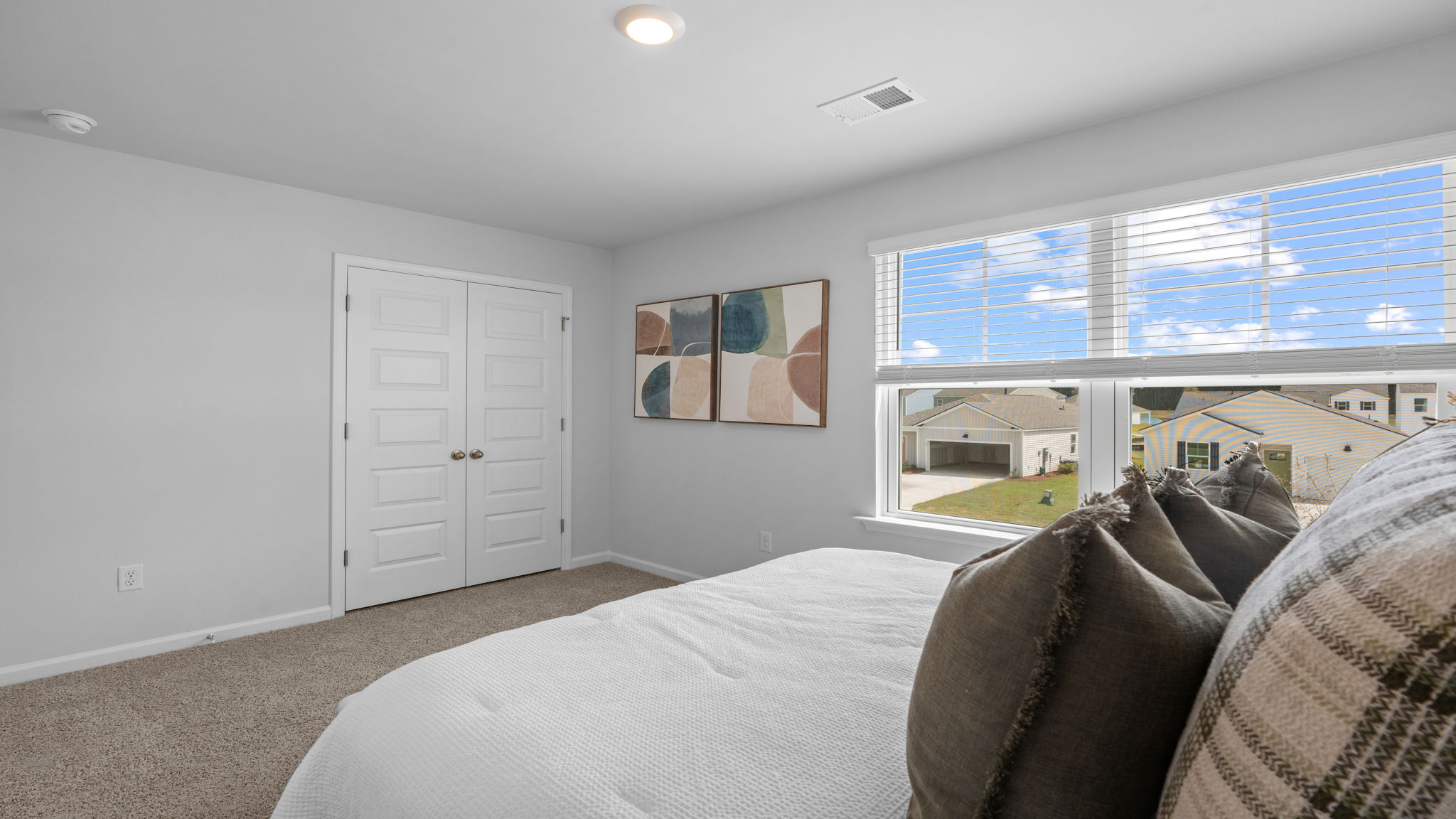 Primary bedroom with wall-to-wall carpeting and large windows