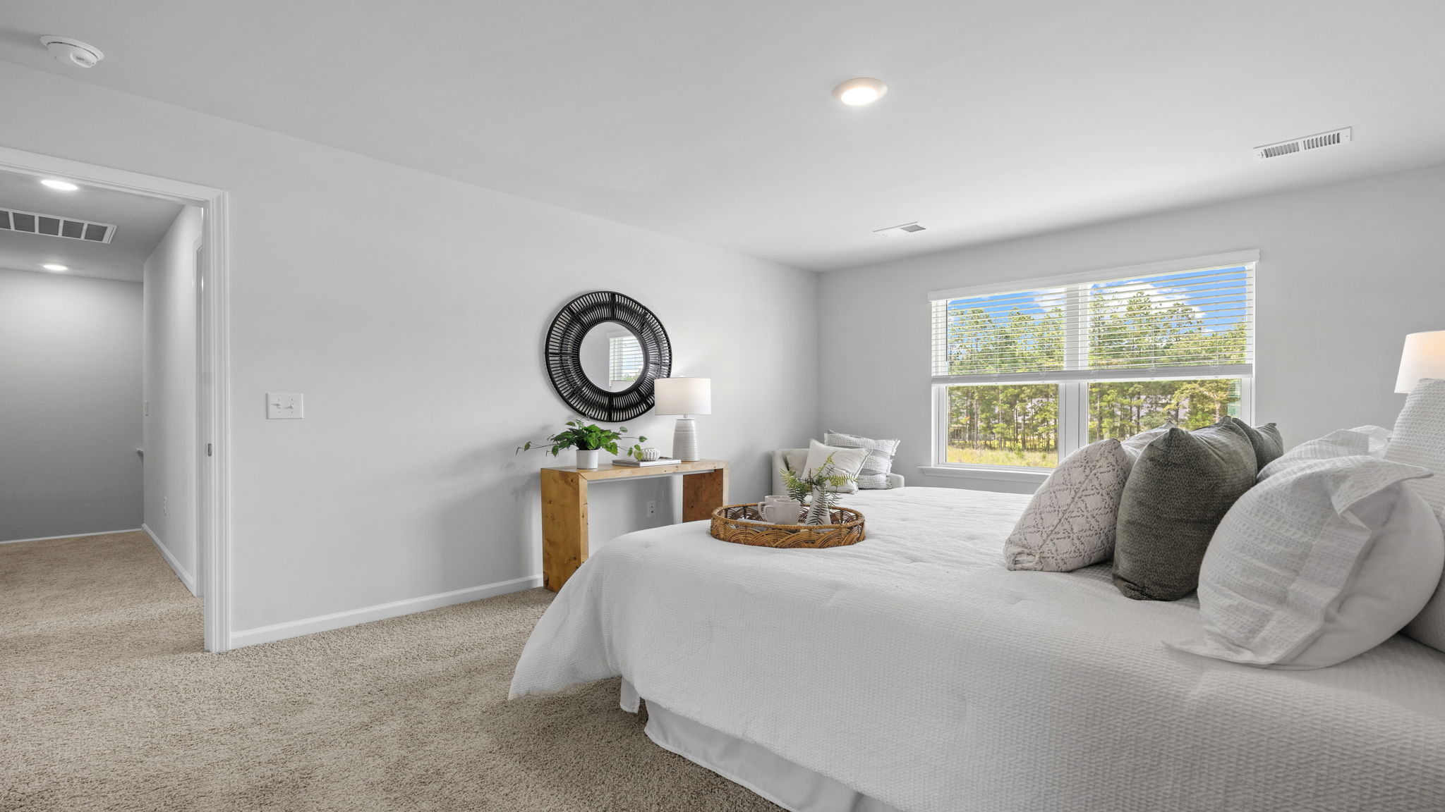 Primary bedroom with large window and neutral finishes