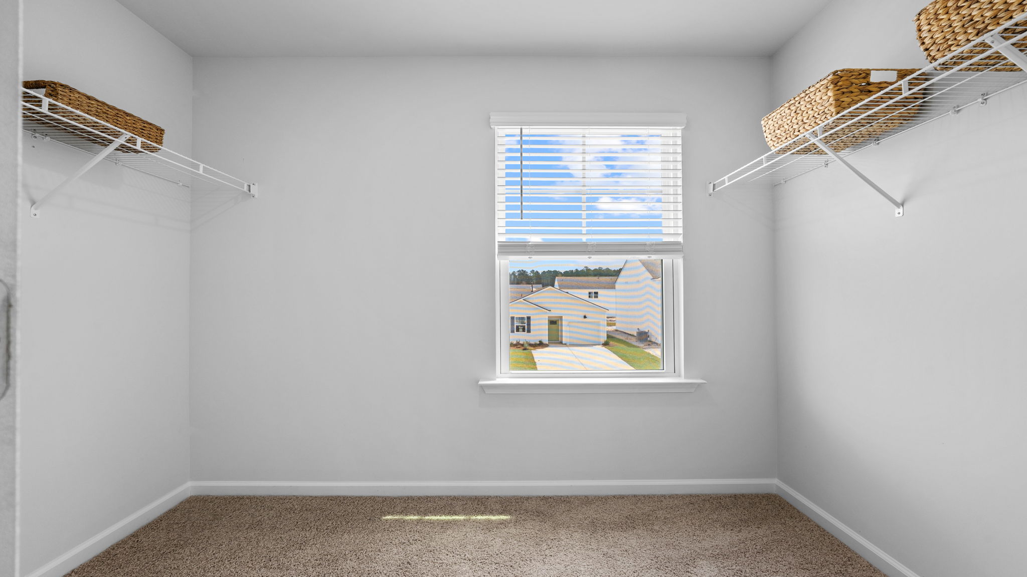 Walk-in closet with window and built-in shelving