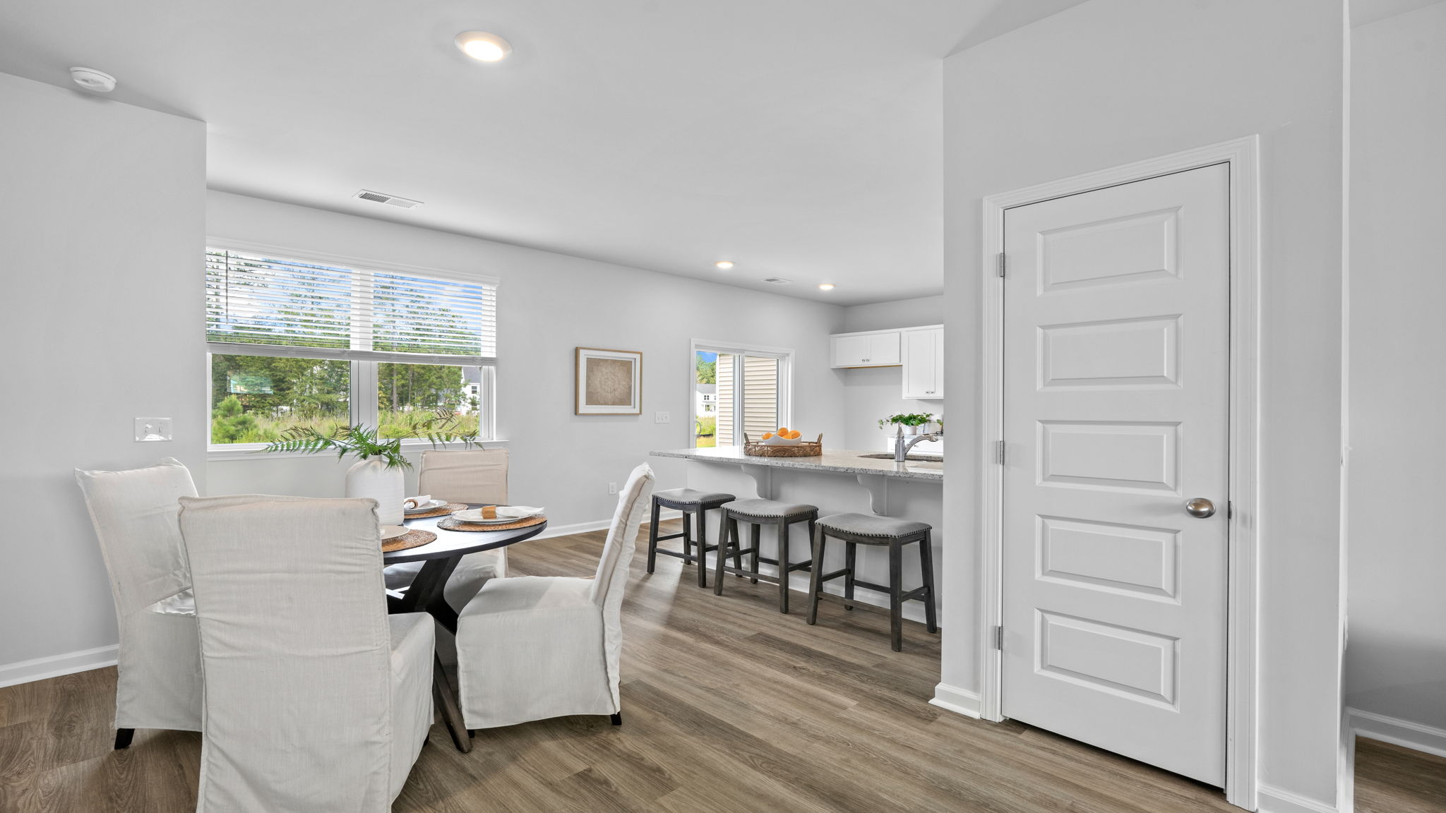 Dining area with natural light and adjacent entryway