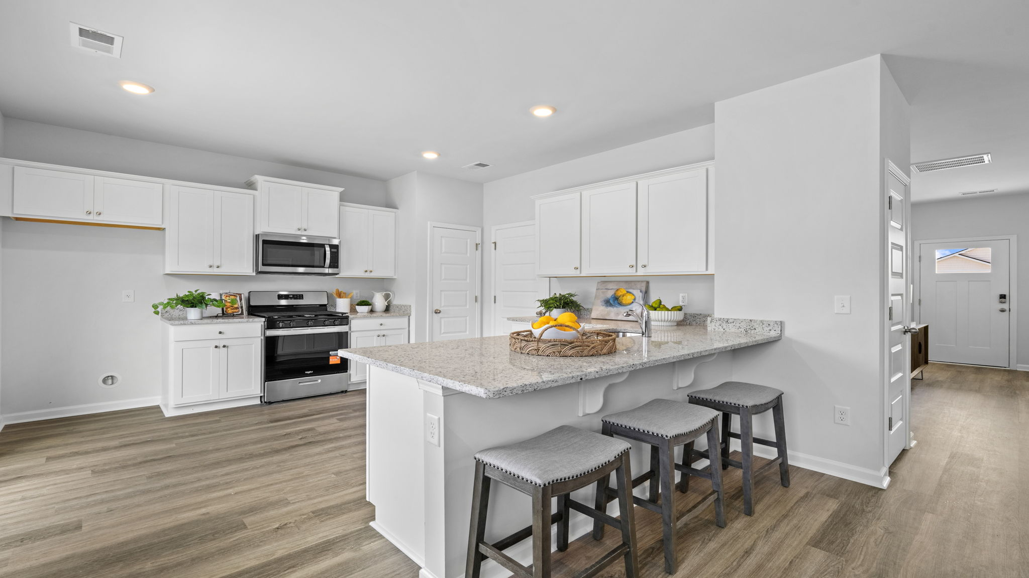 Modern kitchen with center island, bar seating, and white cabinetry