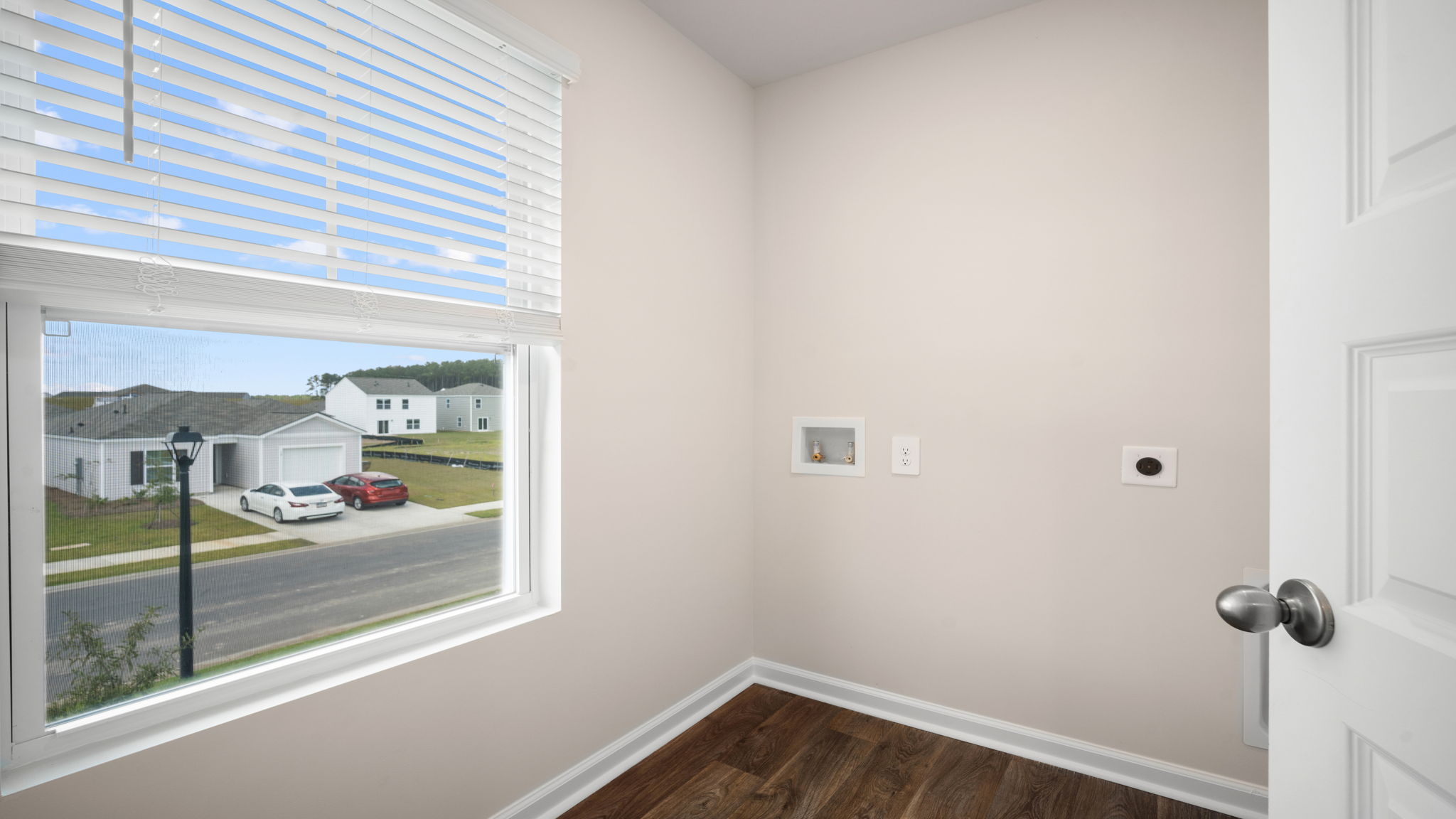 Spacious laundry area has room for a washer and dryer with built in shelves.