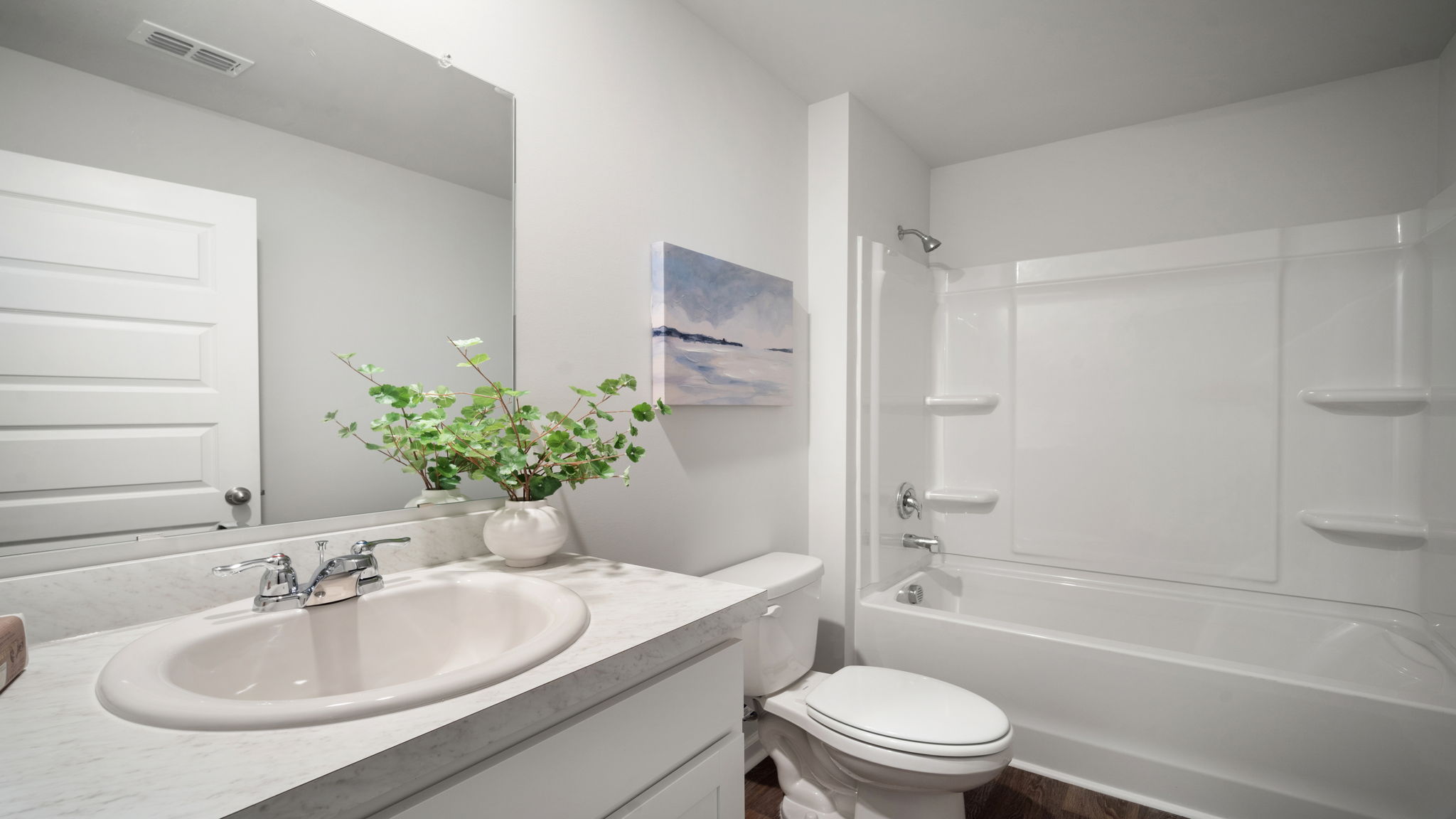 Bathroom with single sink vanity, with shower and tub combination and built in shelving.