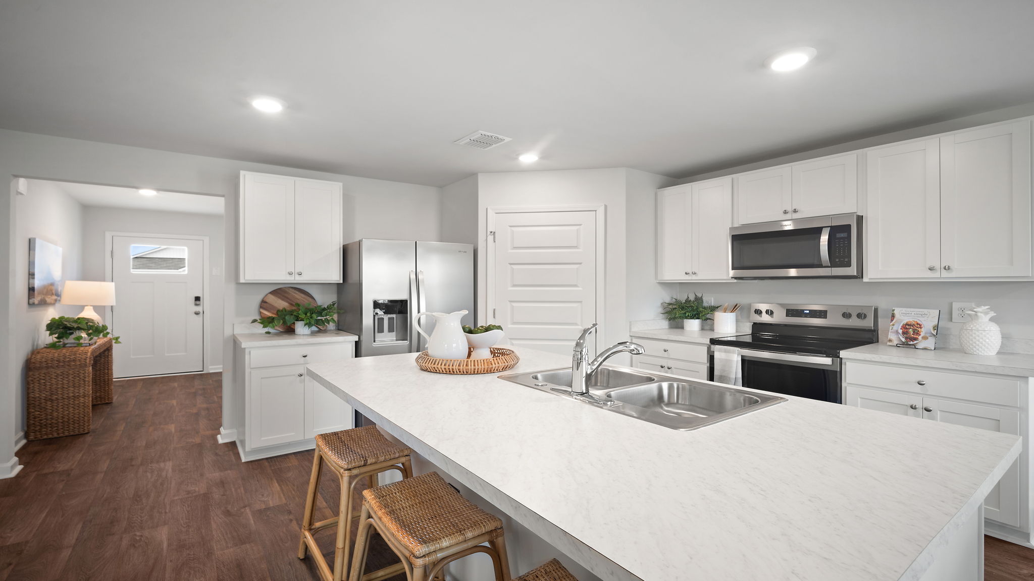 Spacious Kitchen area with granite countertops, large island, cabinets, tile backsplash, and stainless steel appliances