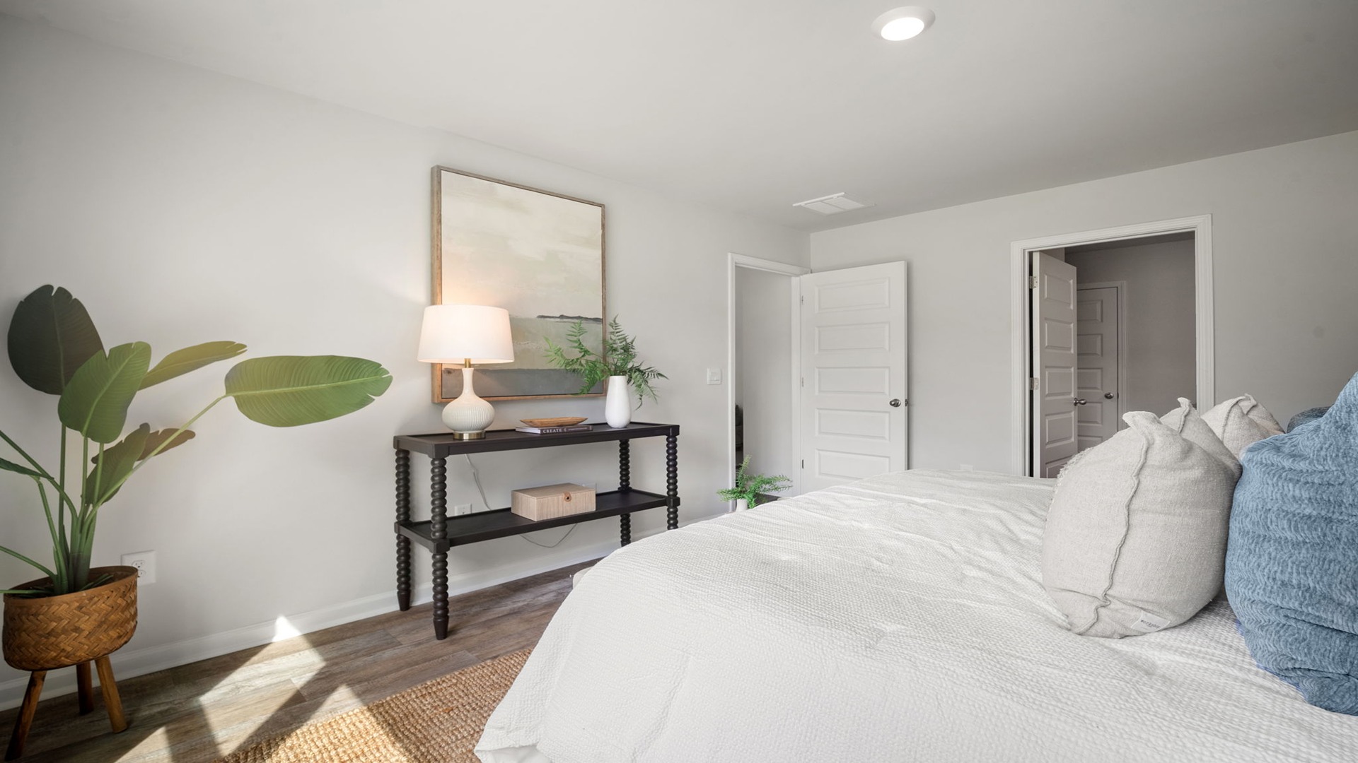 Primary bedroom and door connecting the primary bathroom and entry door.