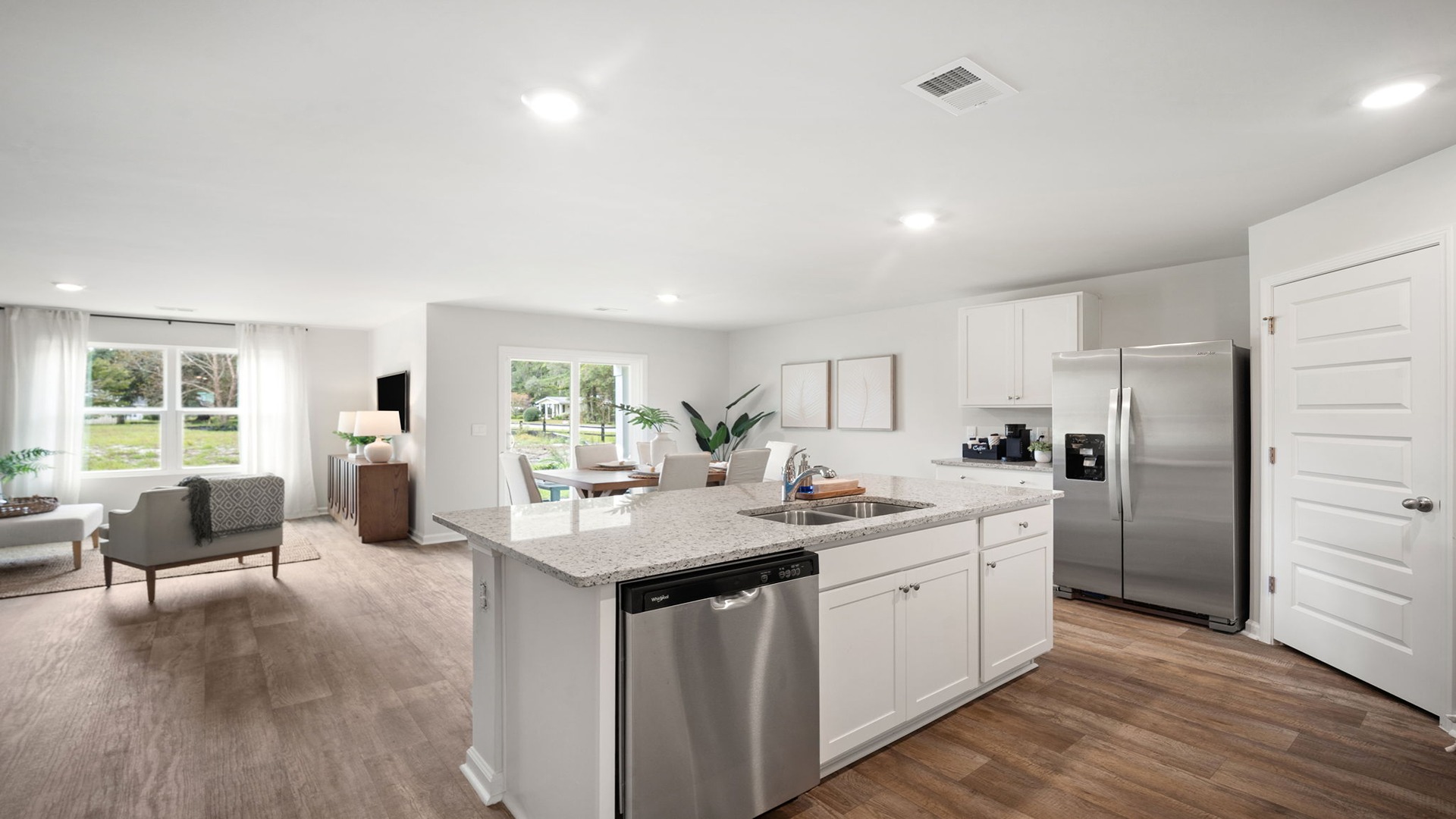 Kitchen area with granite countertops, large island, cabinets, tile backsplash, and stainless steel appliances