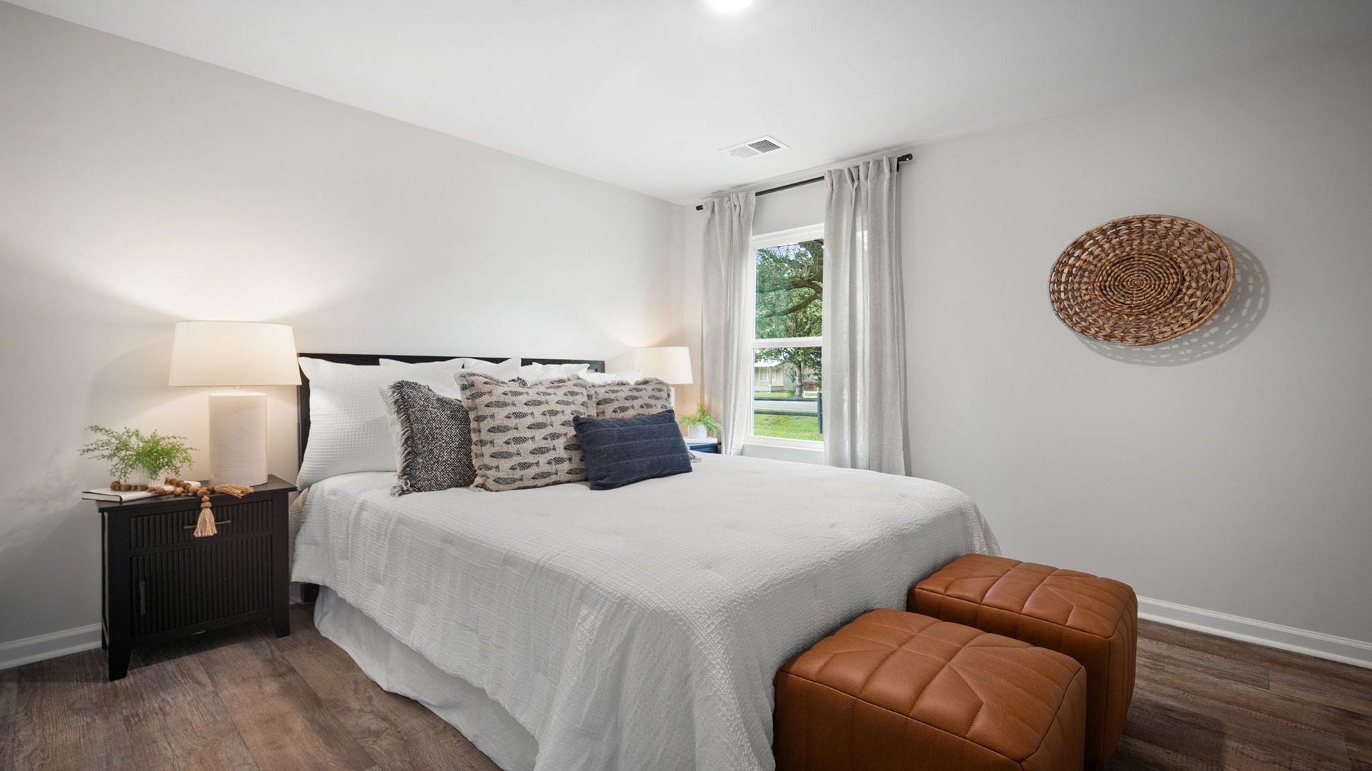 Bedroom with hardwood floors and large single window for natural light.