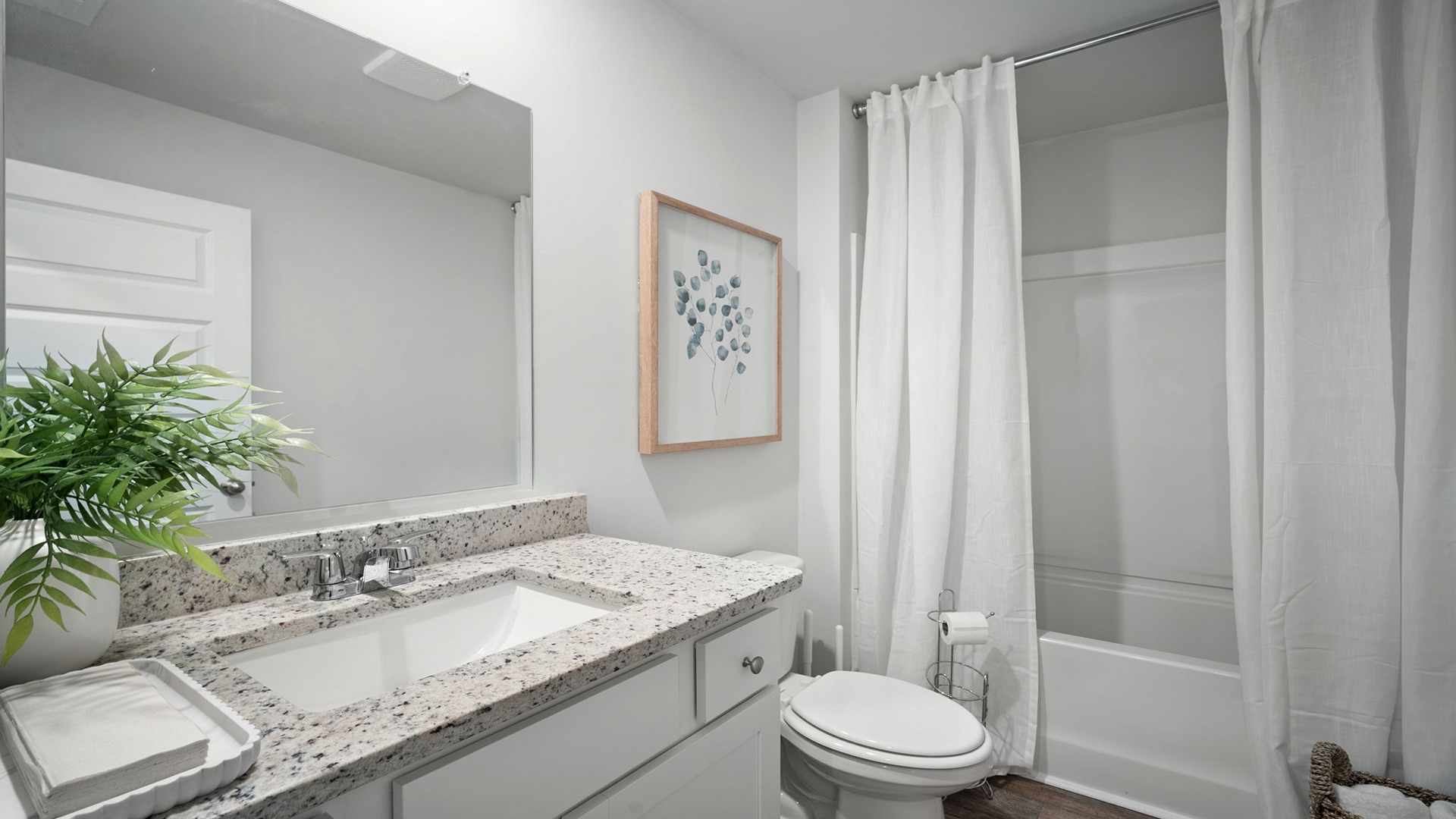 Bathroom with single sink vanity, with shower and tub combination and built in shelving.