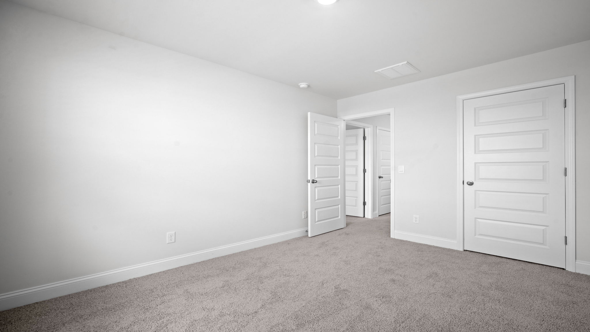 Spacious bedroom with natural light, modern finis